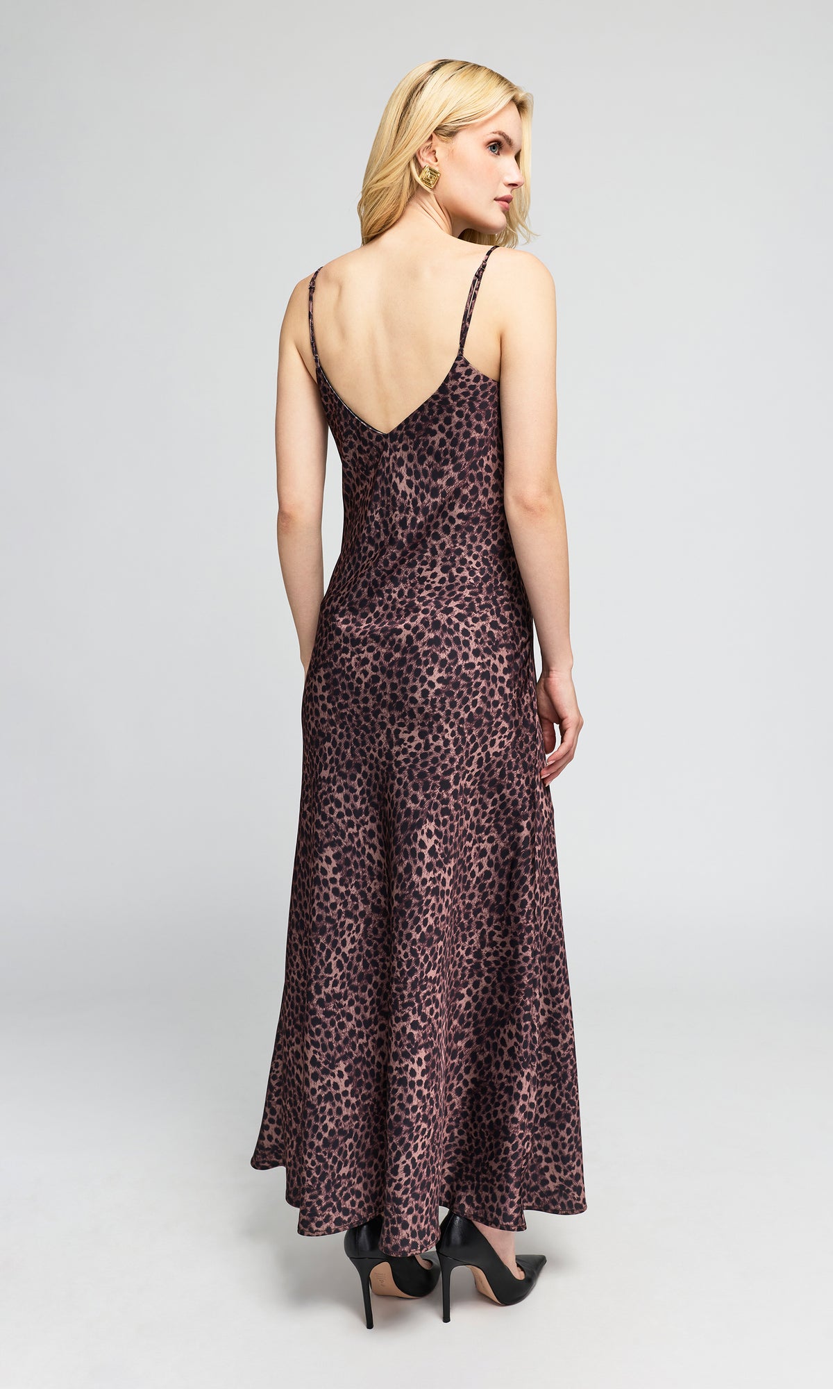Back view of model wearing a floor-length leopard-print slip dress with spaghetti straps and a ruffled sweetheart neckline.