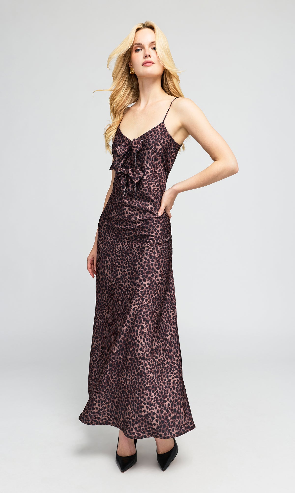 Sid view of model wearing a floor-length leopard-print slip dress with spaghetti straps and a ruffled sweetheart neckline.