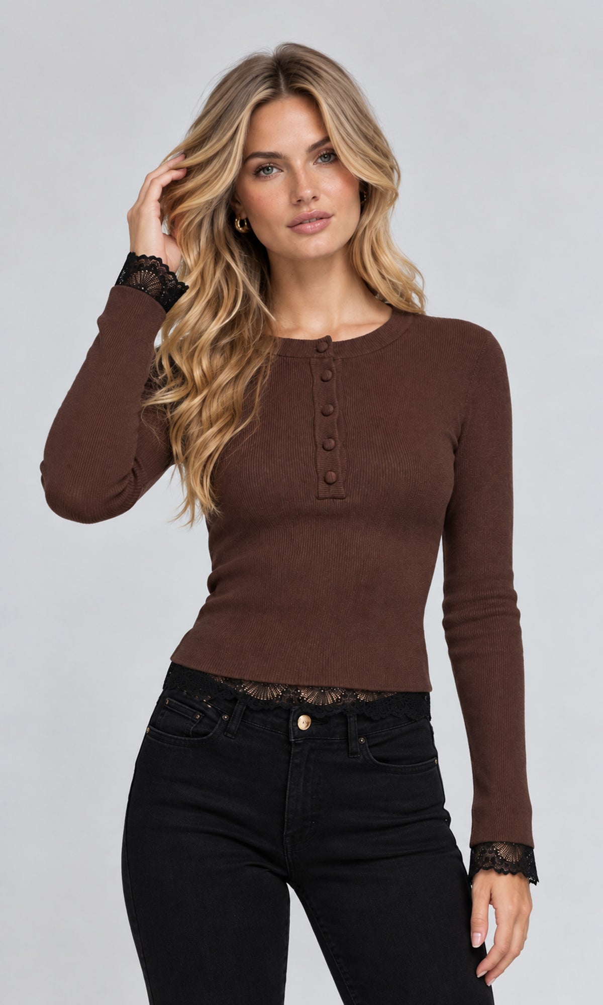 Model wearing a fitted long-sleeve henley top in dark brown with black lace trim at the cuffs and hem, paired with black jeans.