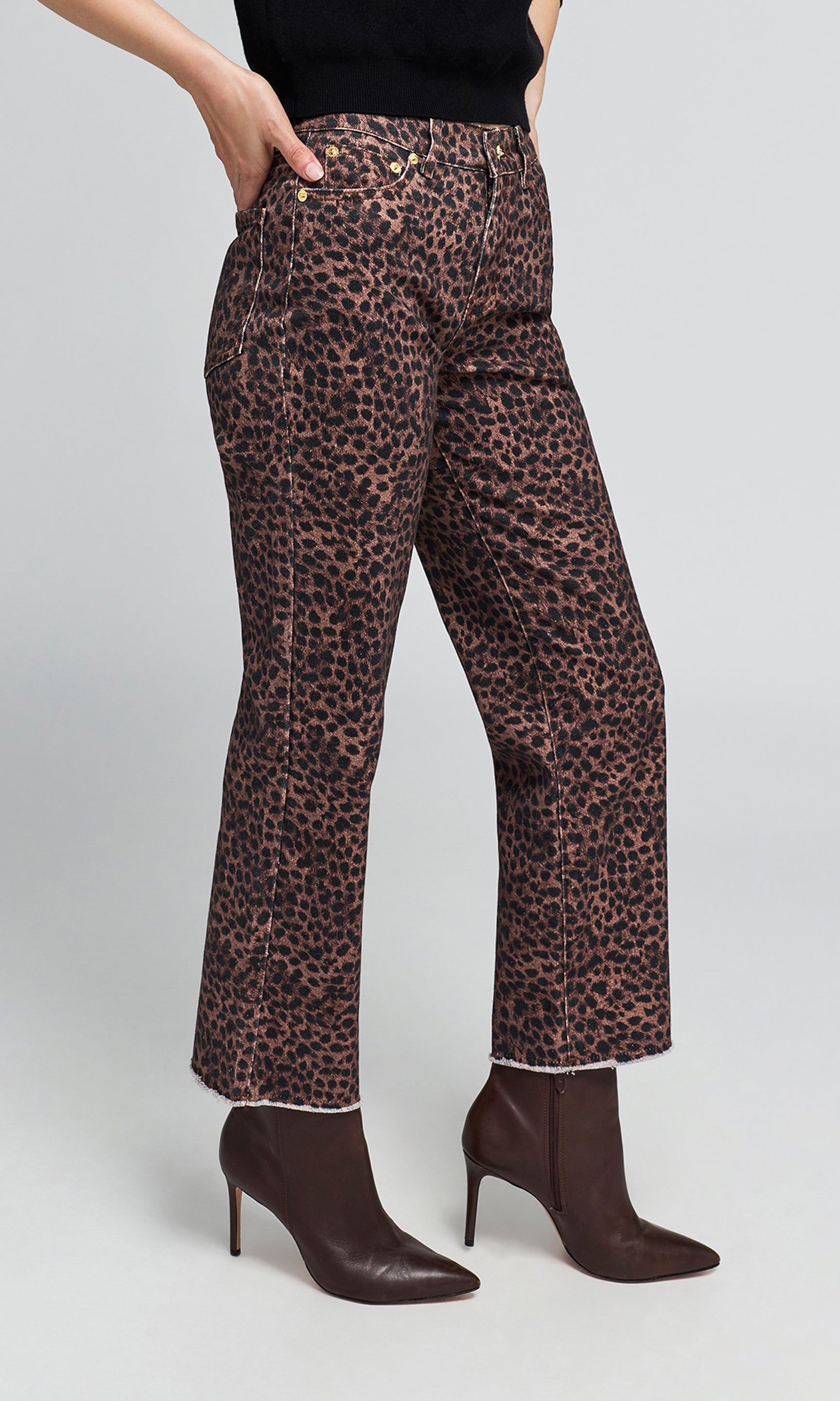 Side view of model wearing high-waisted leopard-print trousers in brown and black, paired with dark brown pointed-toe ankle boots.