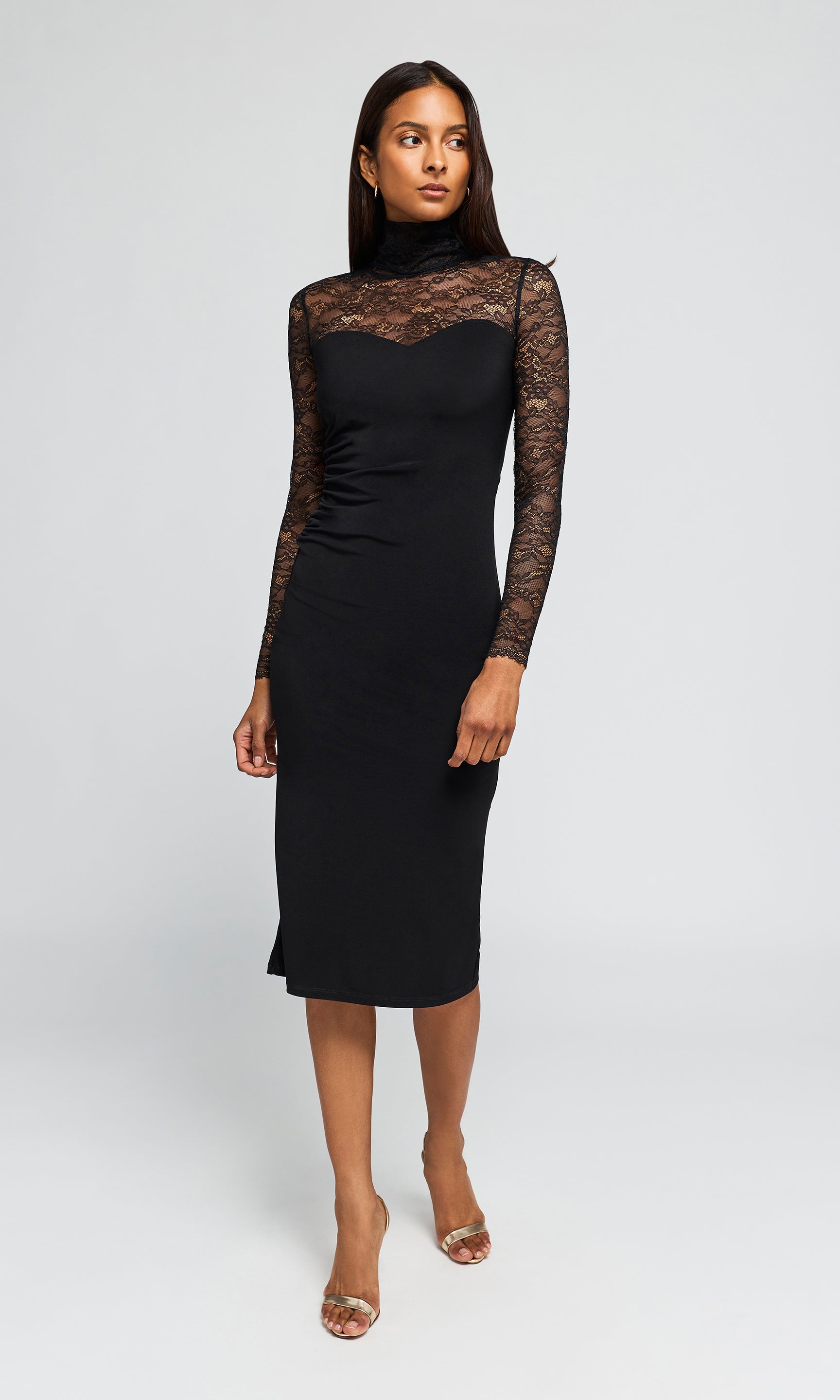 Model wearing a black midi dress with long sheer lace sleeves and a matching black lace yoke across the chest.