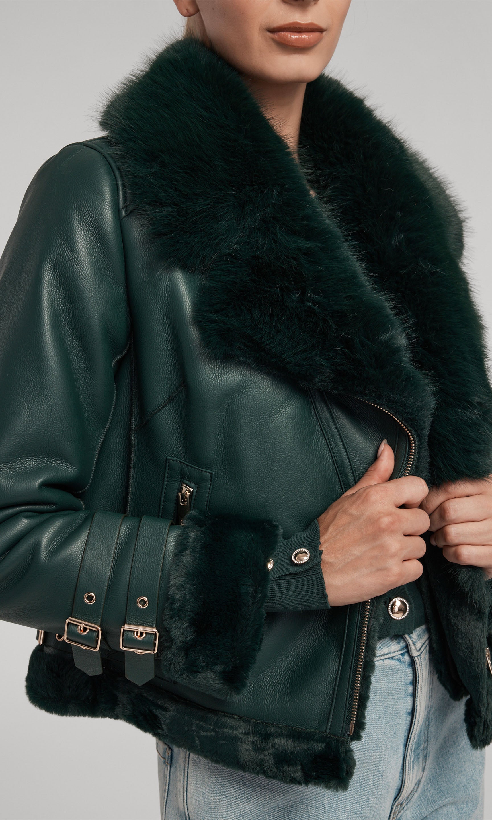 The image depicts a model in a green leather Moto jacket adorned with a luxurious faux fur shearling collar.