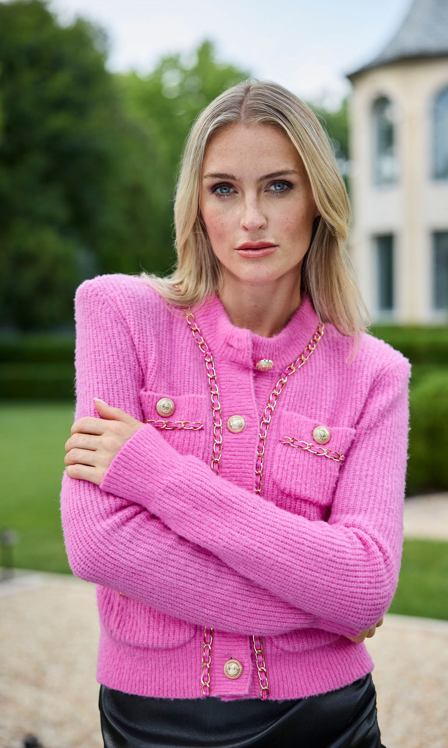 A pink chain cardigan featuring a buttoned front, showcasing a stylish and cozy design suitable for various occasions.