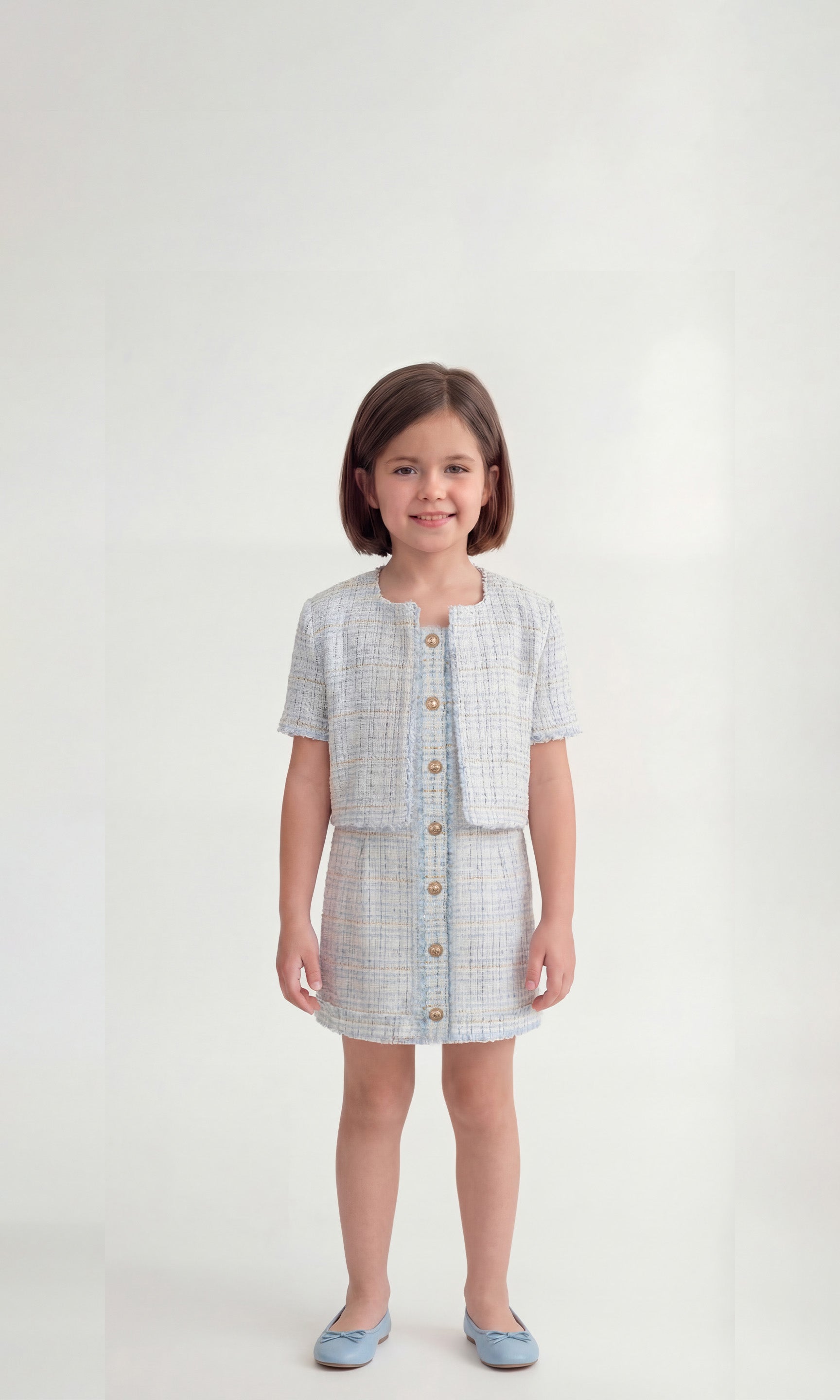 Young girl wearing a checkered dress with a jacket on a white background