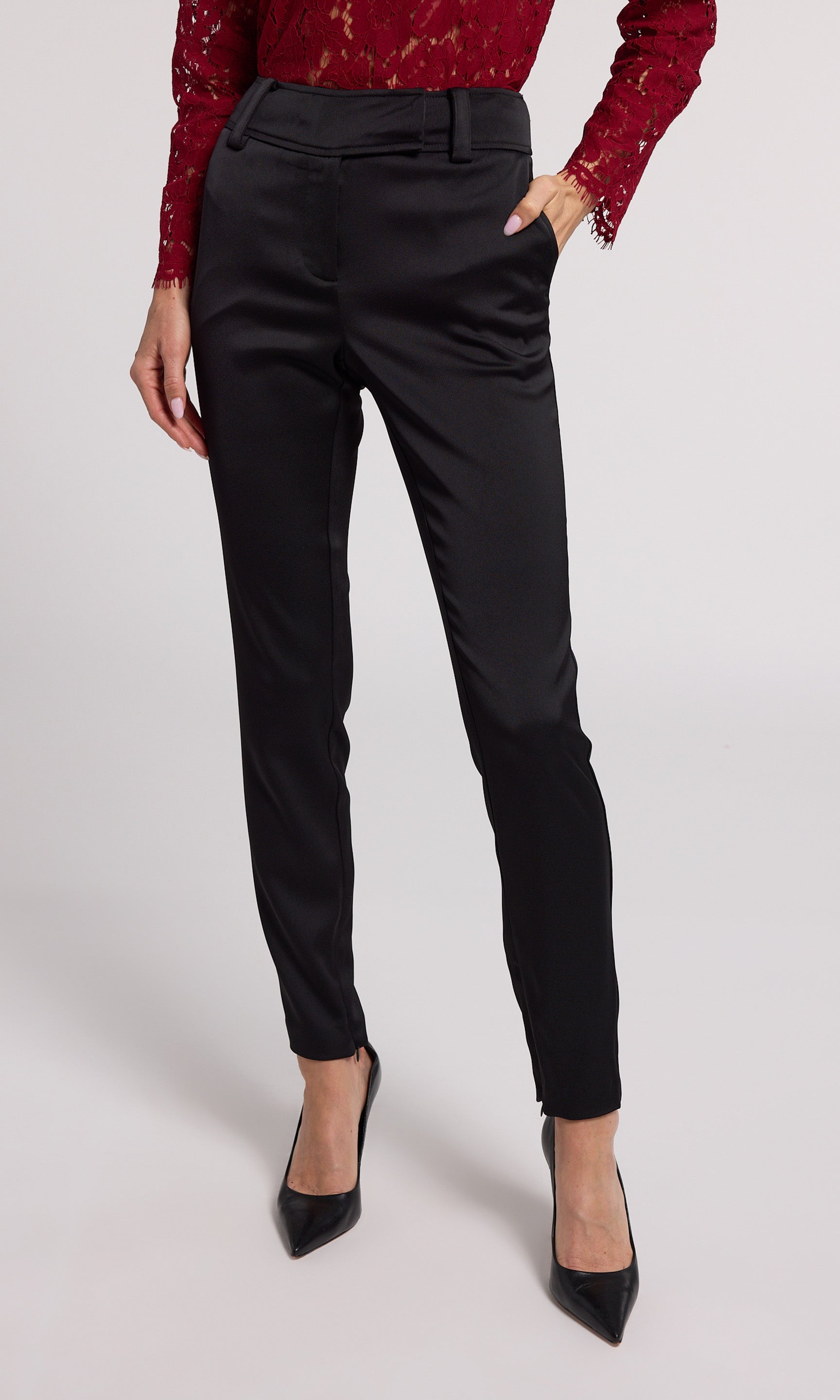 A woman wearing chic black satin pants, highlighting a refined and fashionable appearance.