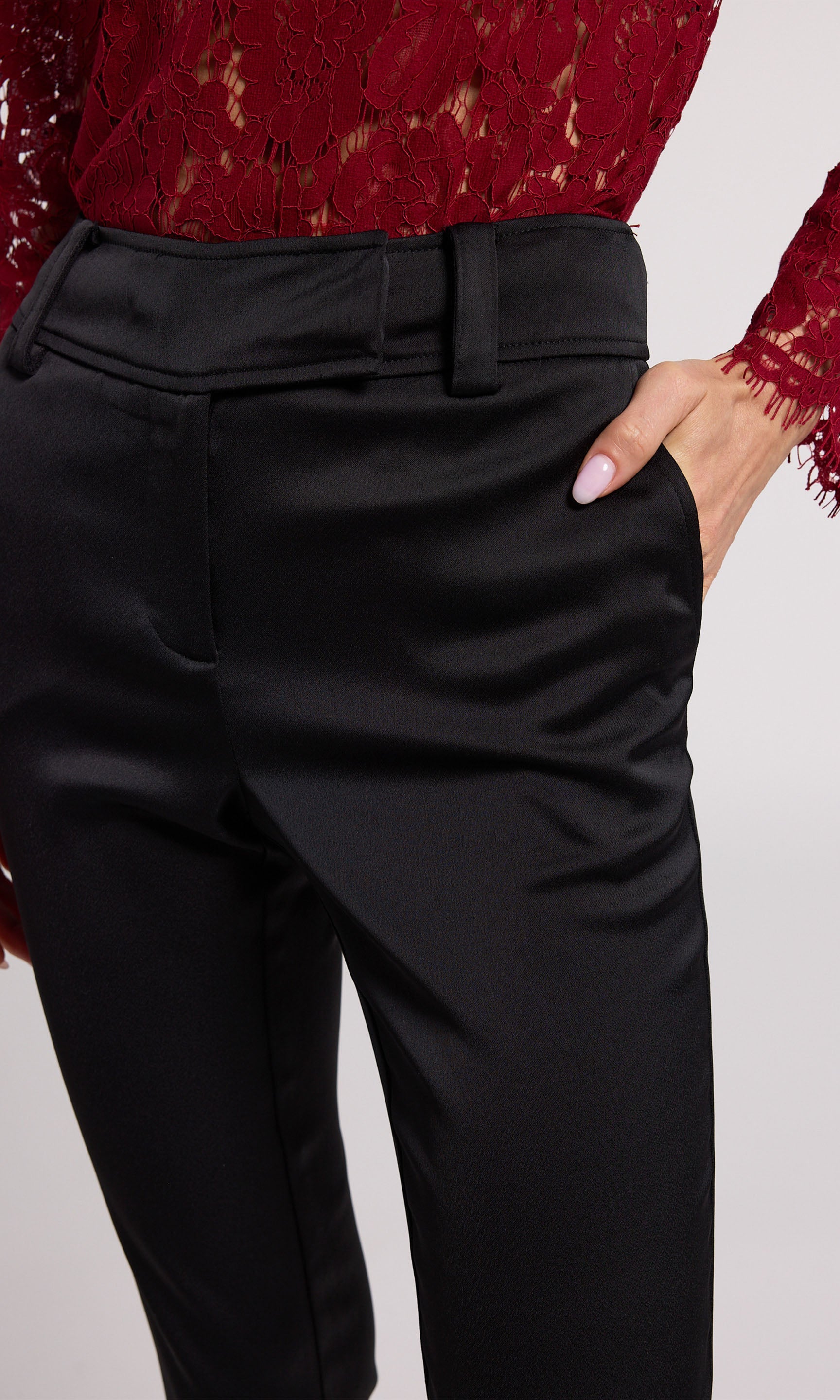 A woman wearing chic black satin pants, highlighting a refined and fashionable appearance.