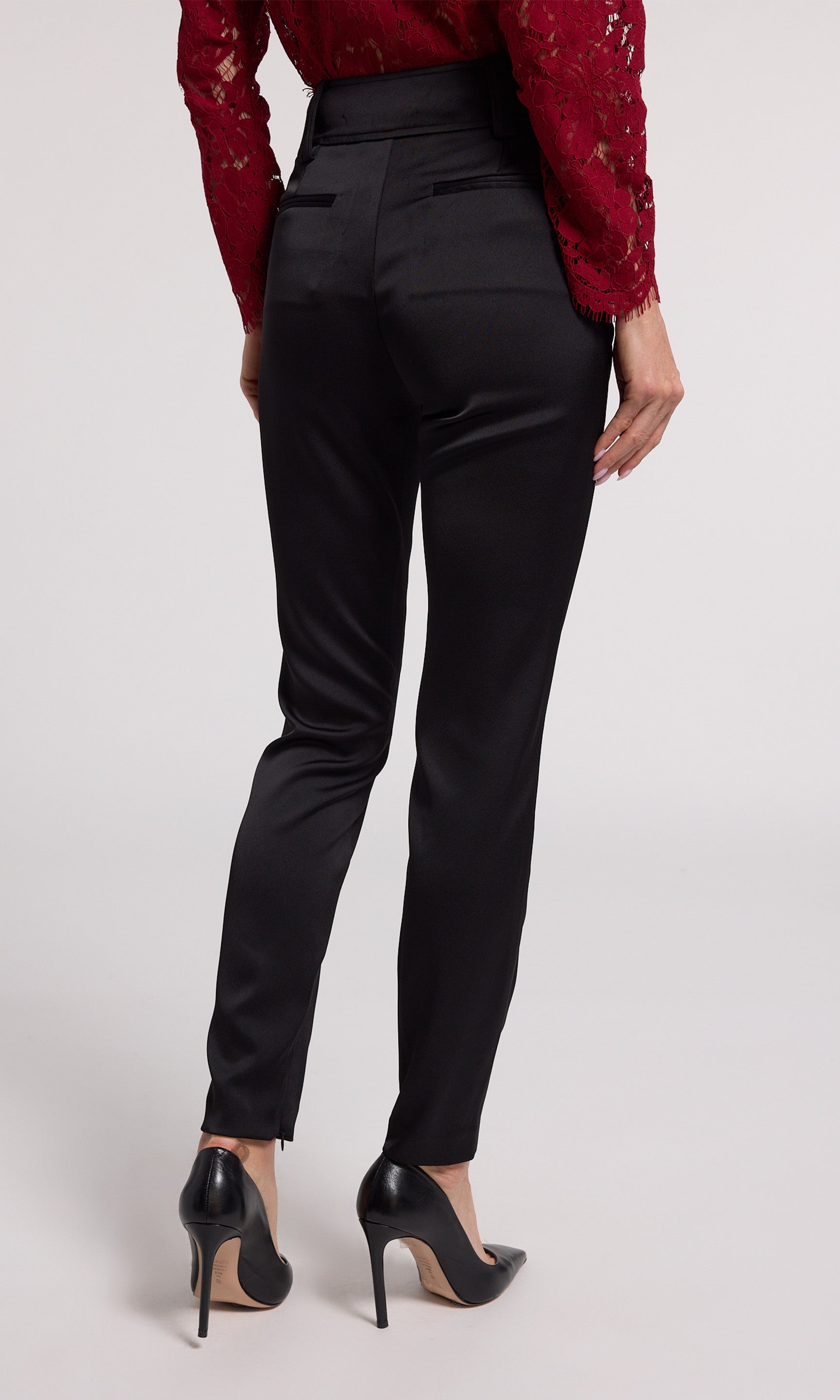 A woman wearing chic black satin pants, highlighting a refined and fashionable appearance.