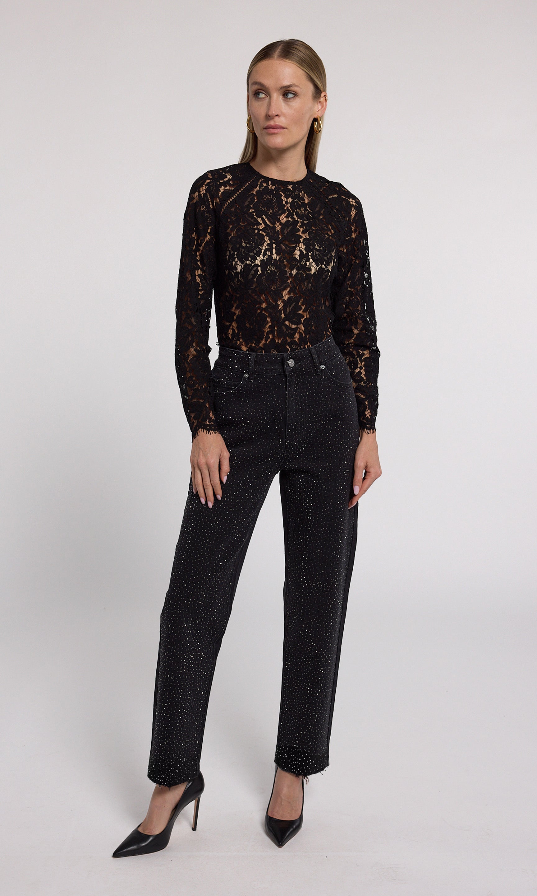 A close-up of black jeans featuring crystal embellishments, showcasing a stylish and elegant design.