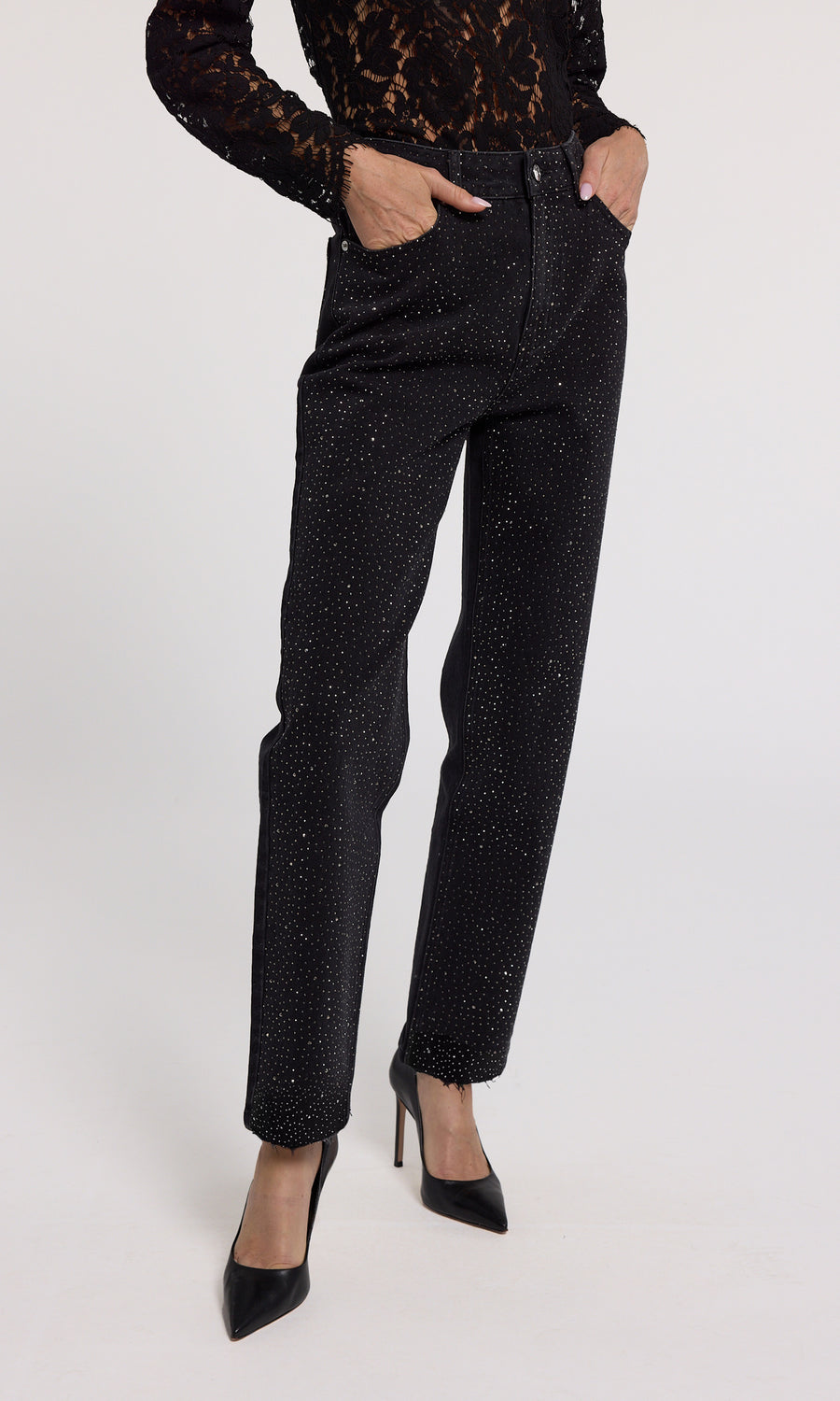 A close-up of black jeans featuring crystal embellishments, showcasing a stylish and elegant design.