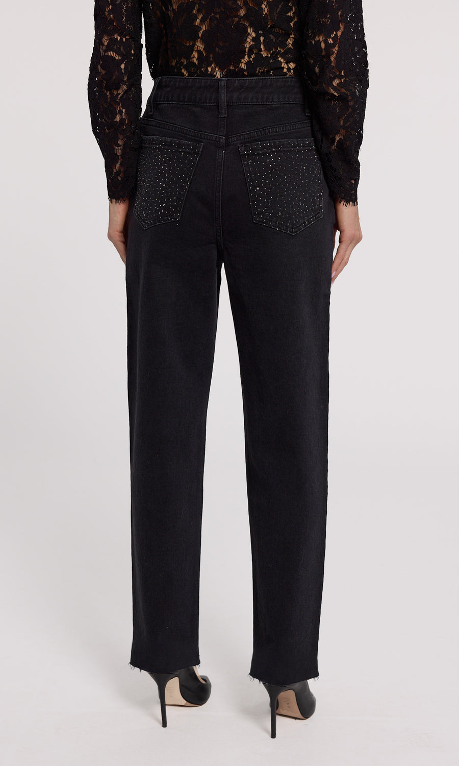 A close-up of black jeans featuring crystal embellishments, showcasing a stylish and elegant design.