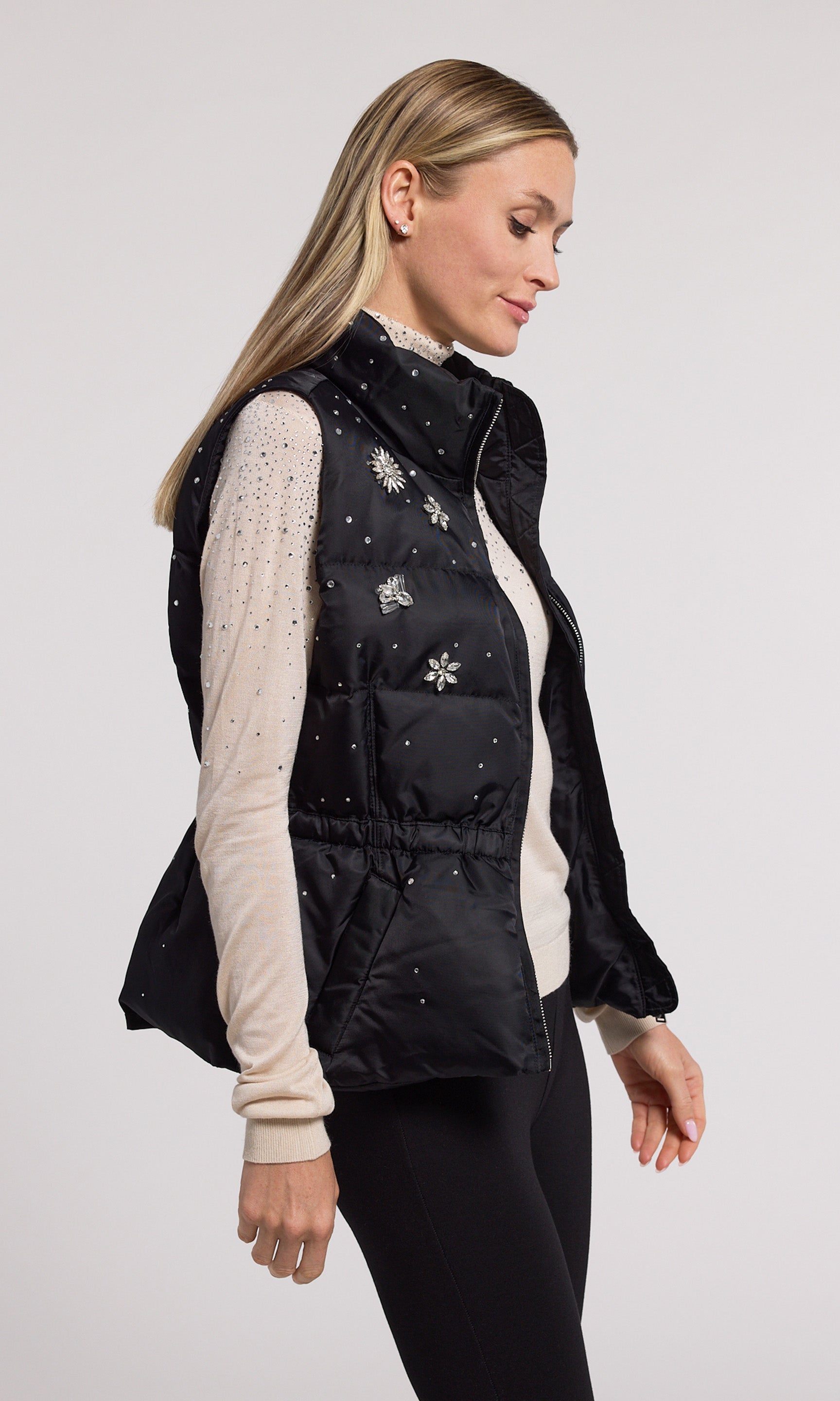A black puffer vest adorned with delicate crystals, showcasing a stylish winter design perfect for cold weather.