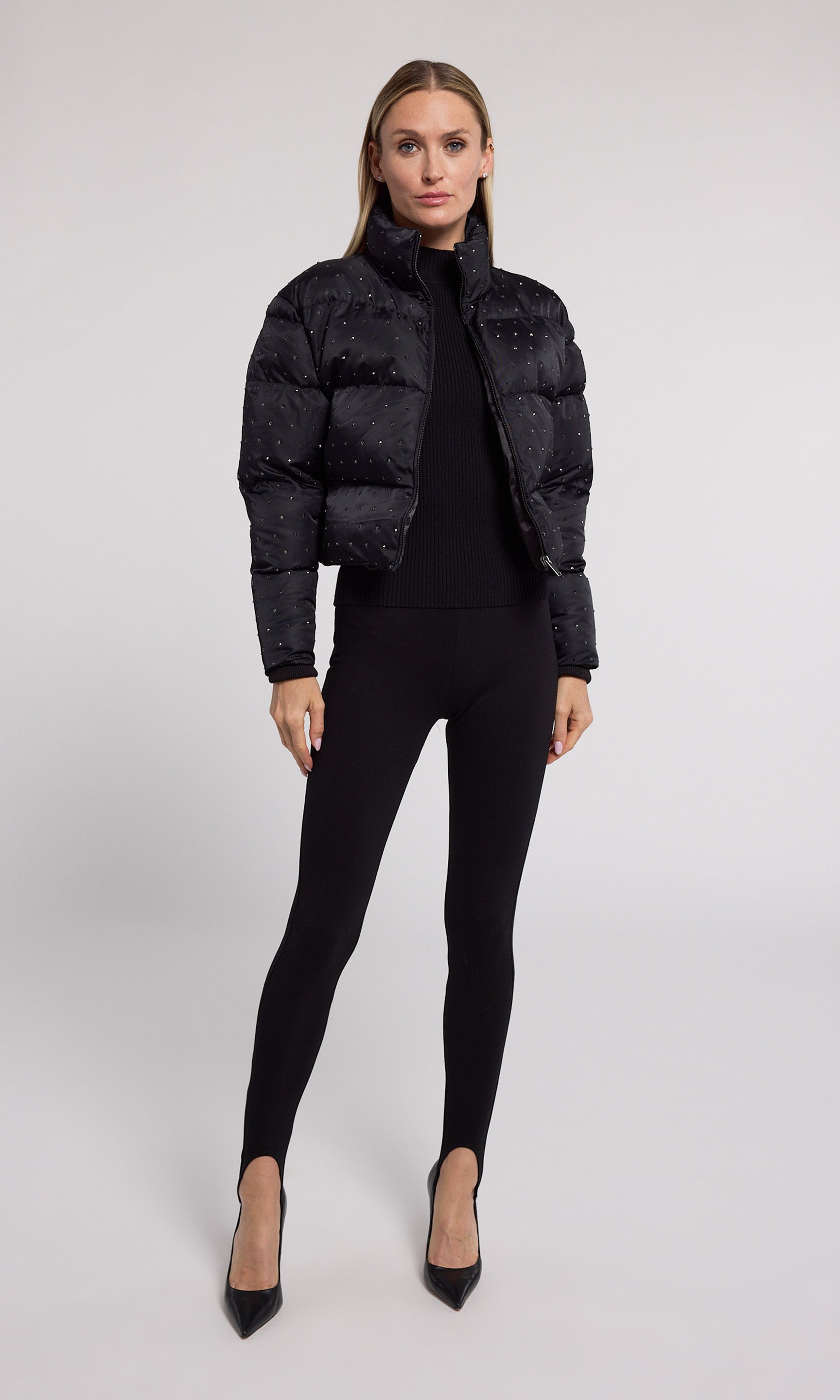 A stylish black cropped puffer adorned with crystal, showcasing a modern and playful design.