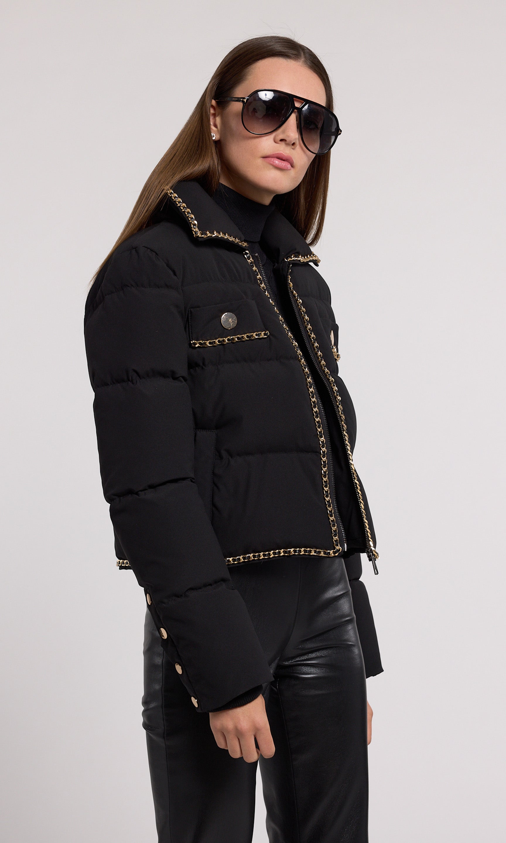 A stylish black puffer jacket featuring elegant gold detailing, perfect for a chic and modern look.