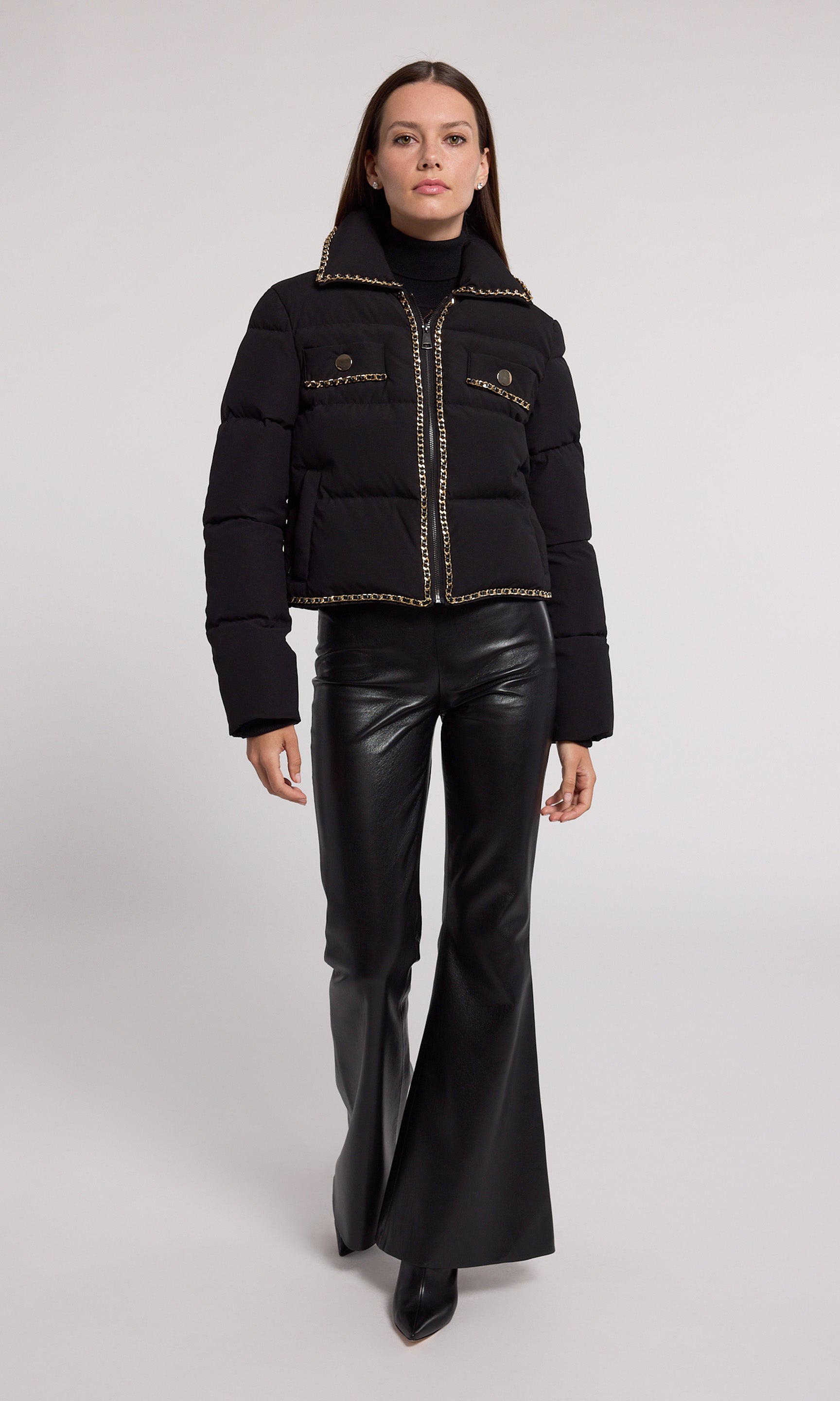 A stylish black puffer jacket featuring elegant gold detailing, perfect for a chic and modern look.