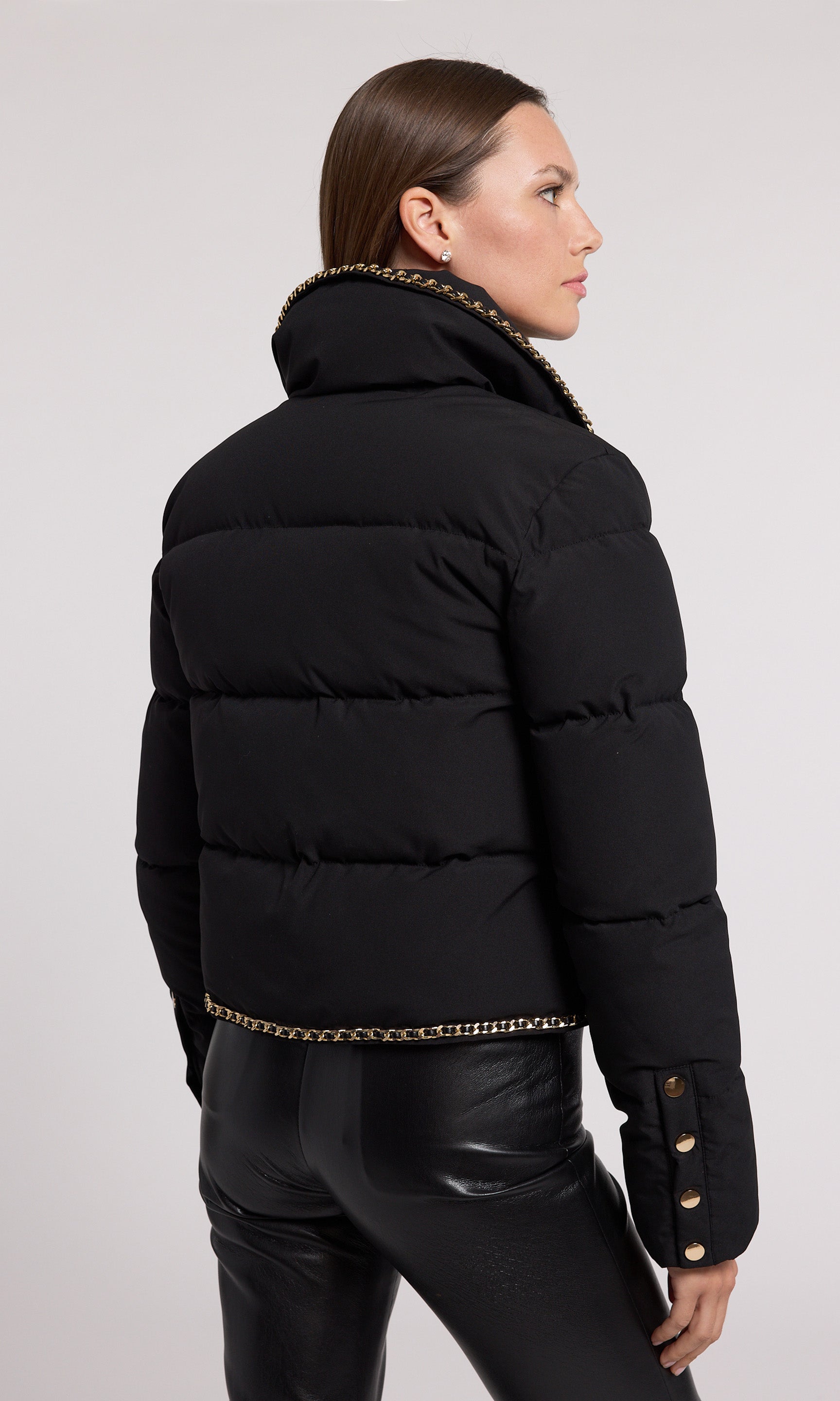 A stylish black puffer jacket featuring elegant gold detailing, perfect for a chic and modern look.