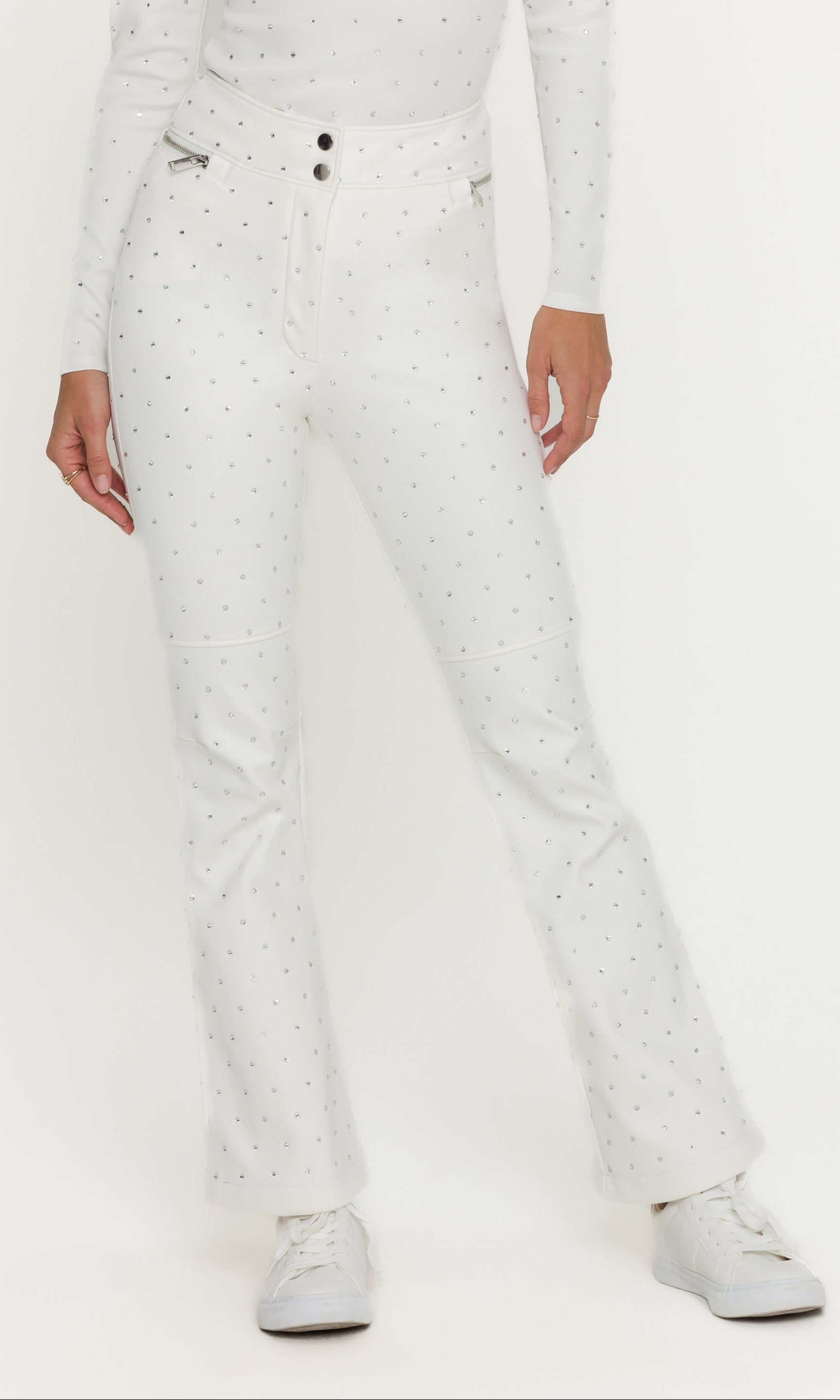 Person wearing a white outfit with crystal embellishments on a white background