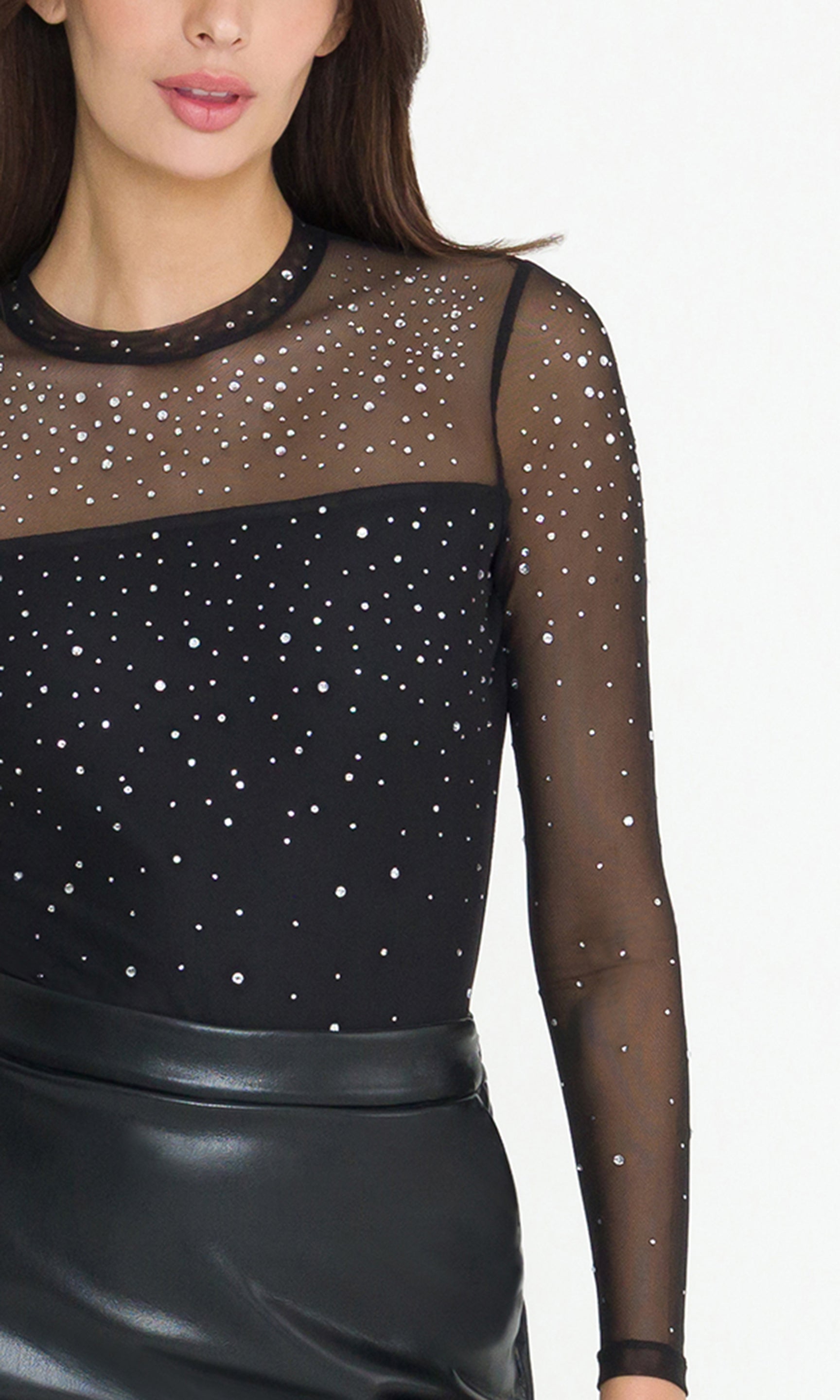 Black sheer top with sparkling details worn by a model on a white background