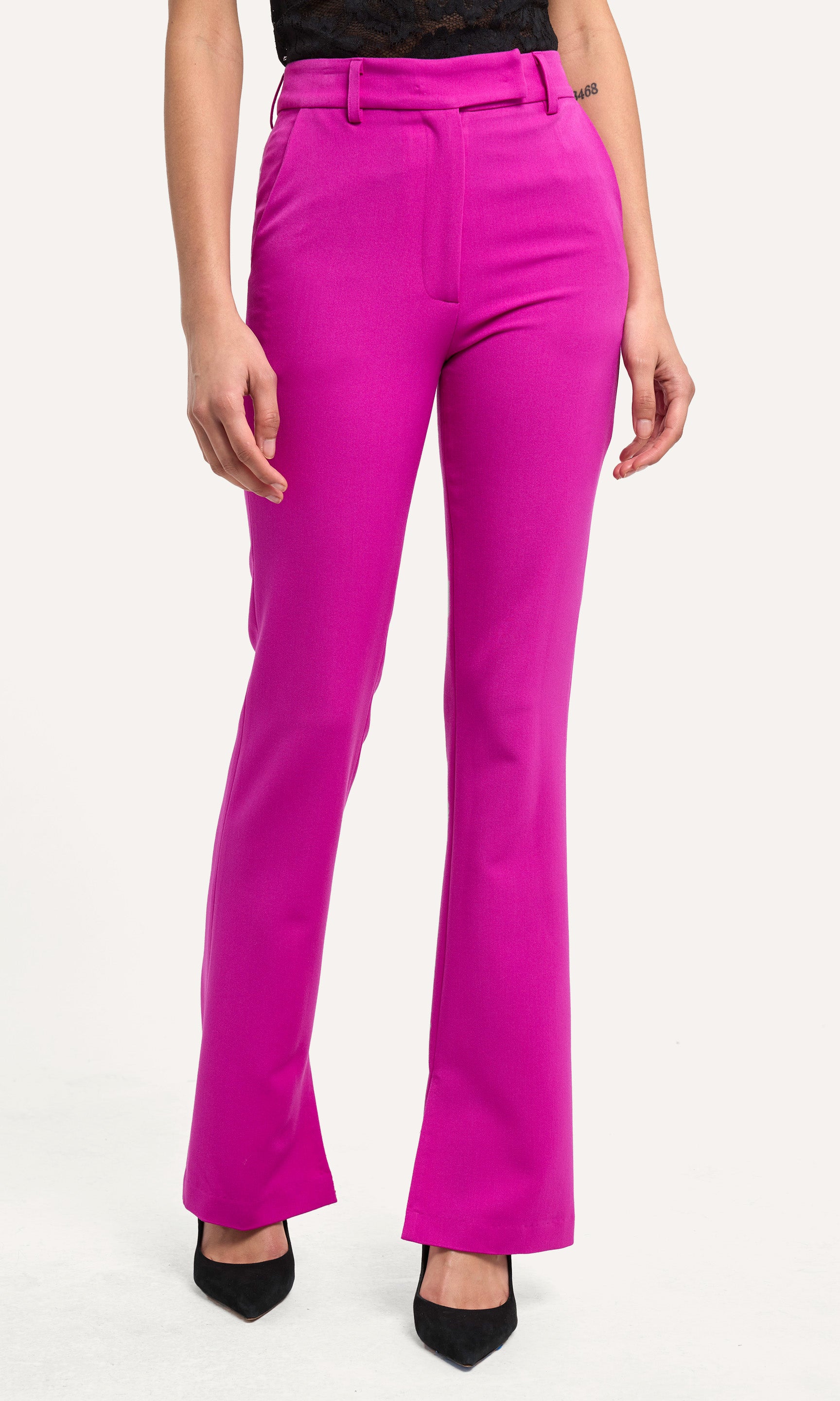Bright pink pants worn by a person on a white background
