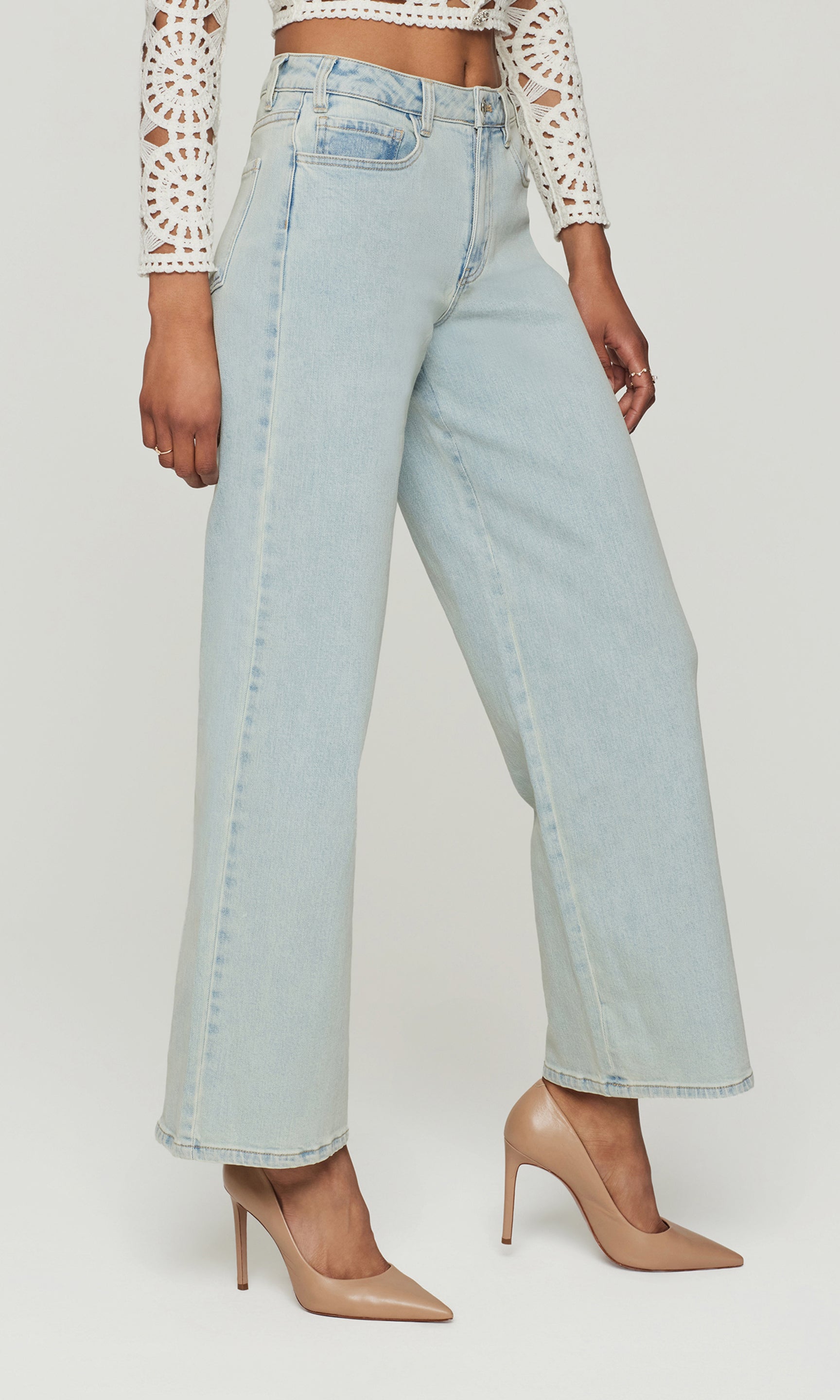 Side view of light blue jeans worn by a person on a white background