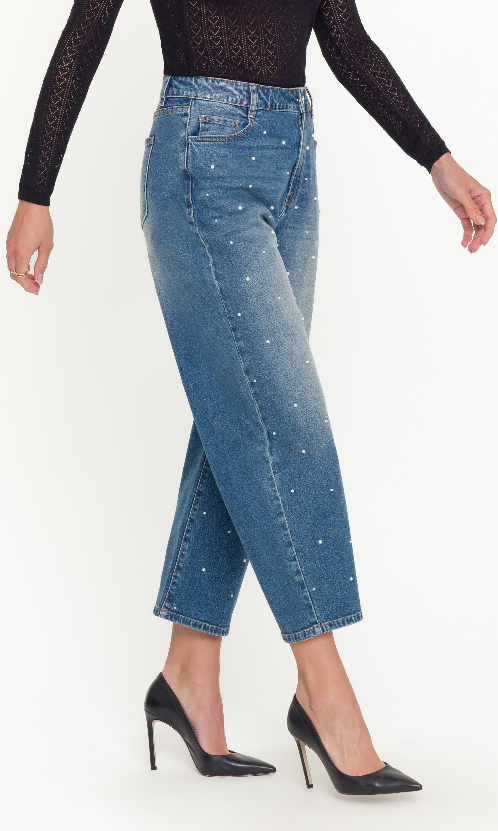 Blue jeans with rhinestone embellishments worn by a person on a white background