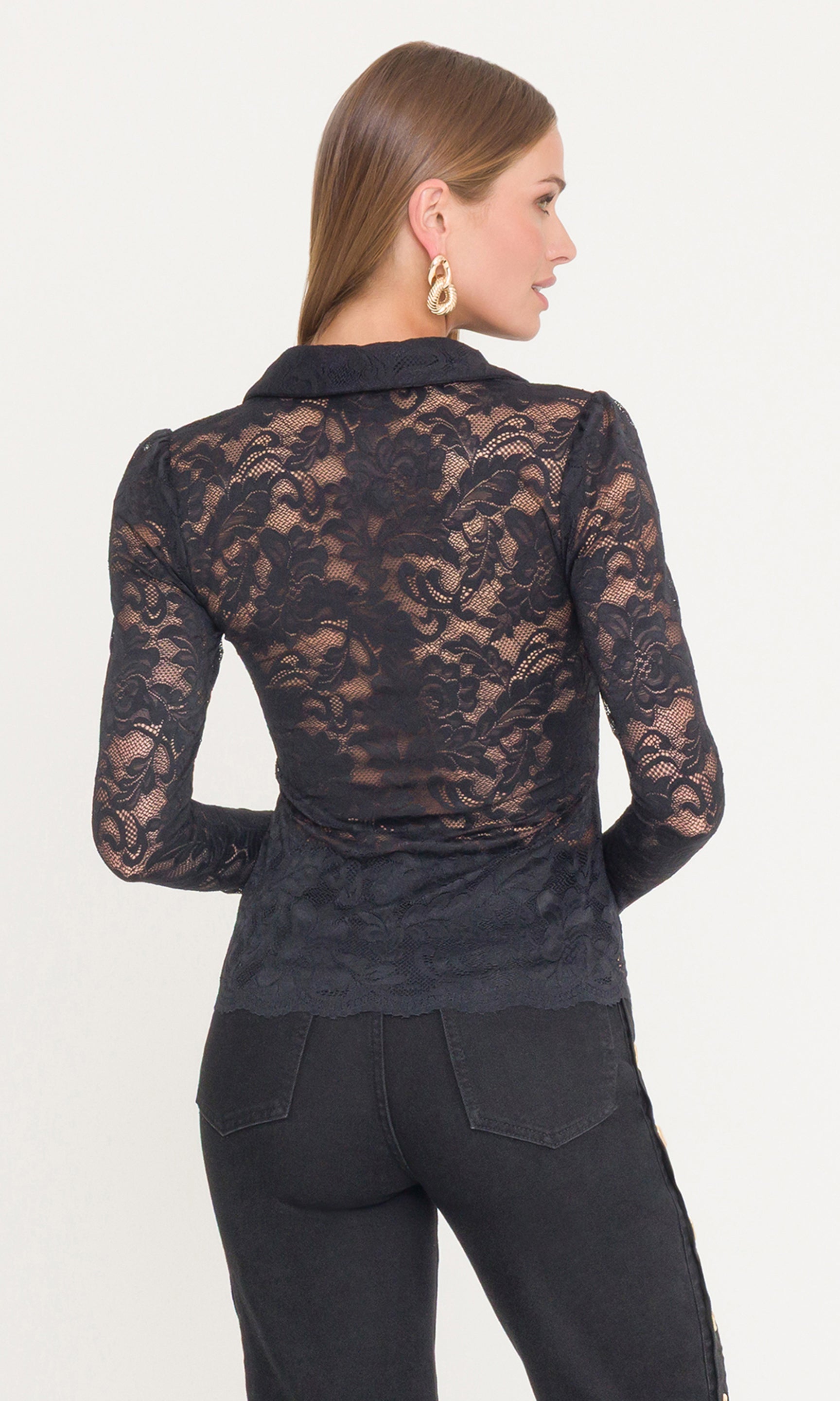 Back view of model wearing a black lace long sleeve top and black pants