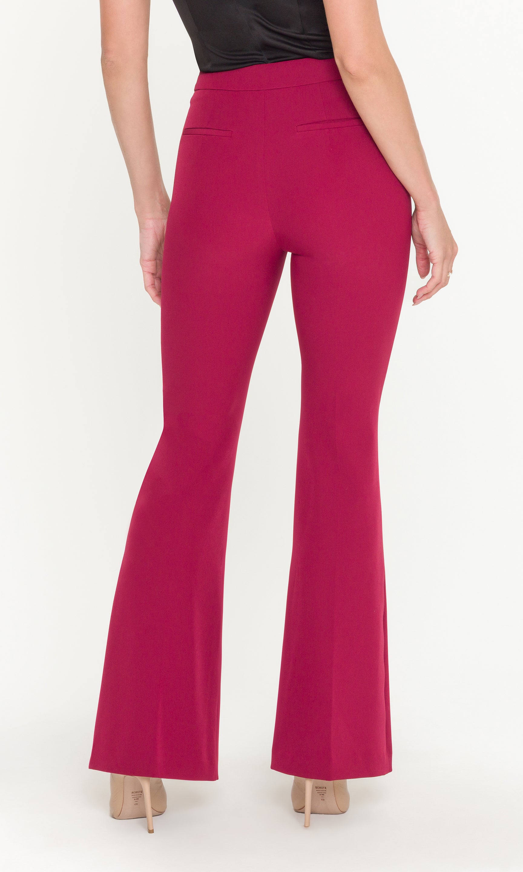 Crimson flared pants worn by a person on a white background