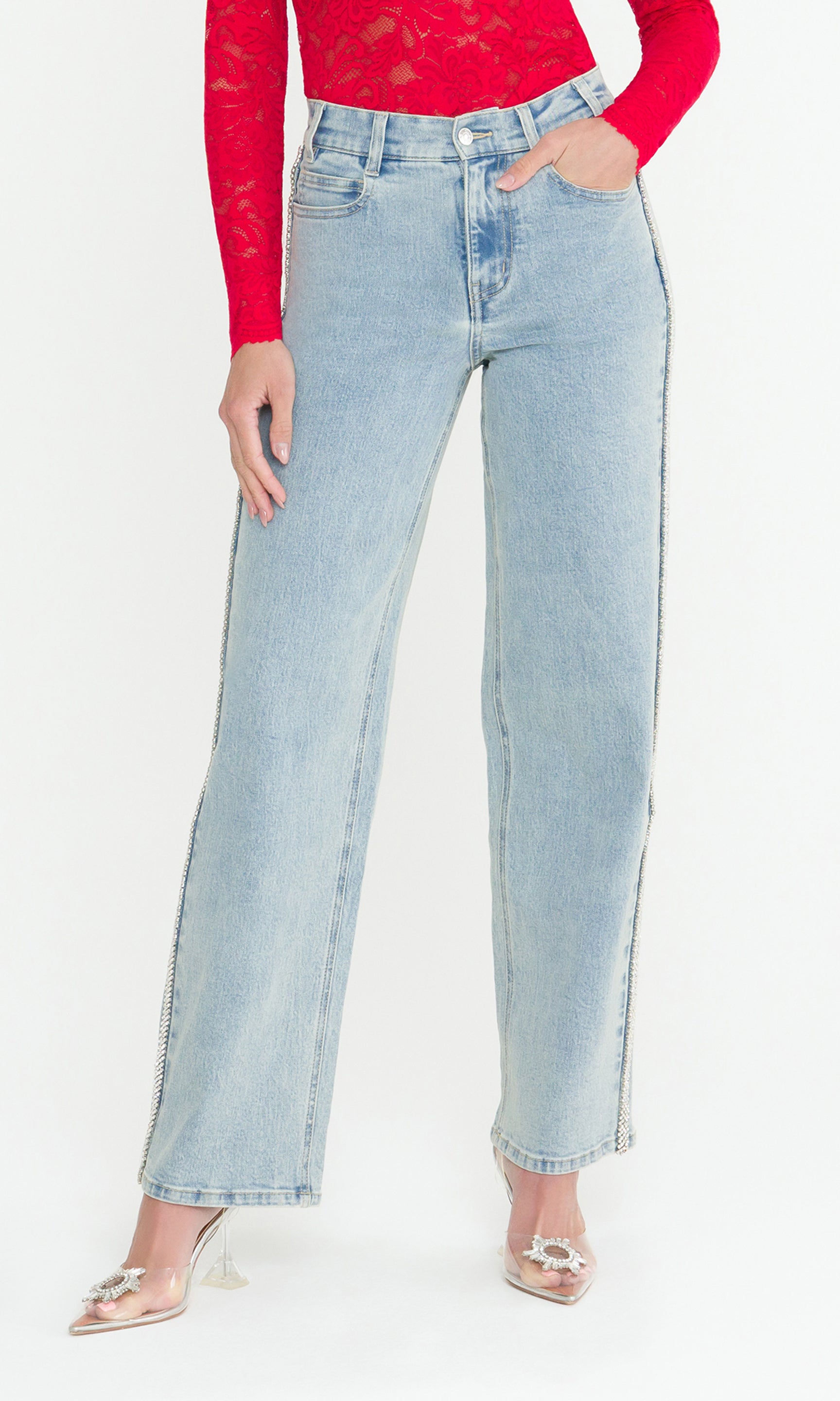 Model wearing light blue jeans and a red top on a white background