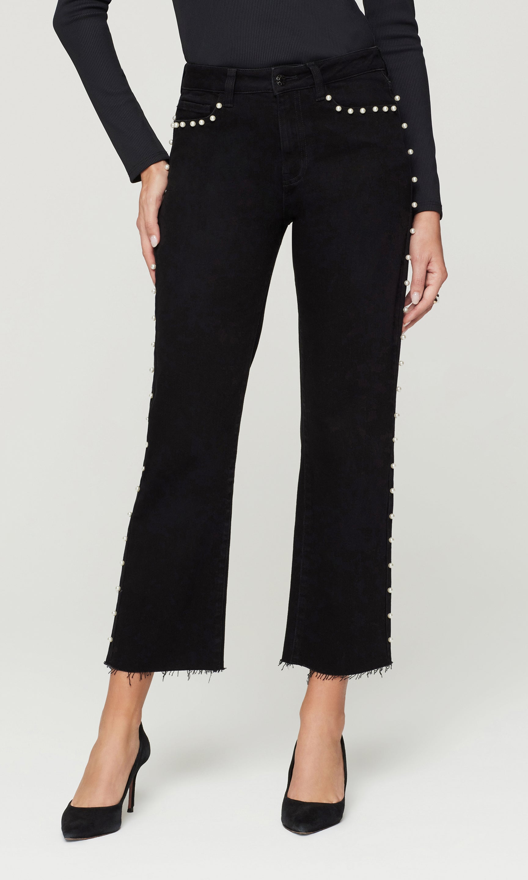 Black jeans with pearl embellishments on a white background