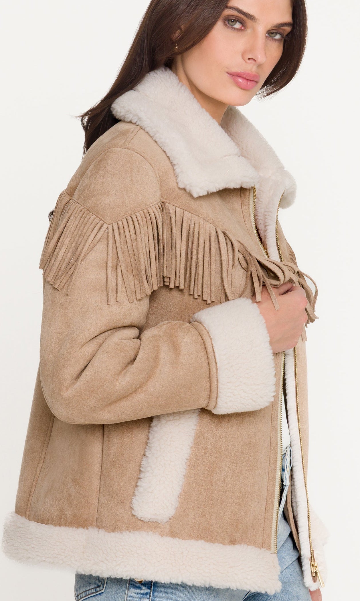 Close-up of woman wearing a beige suede jacket with white fur trim on a white background