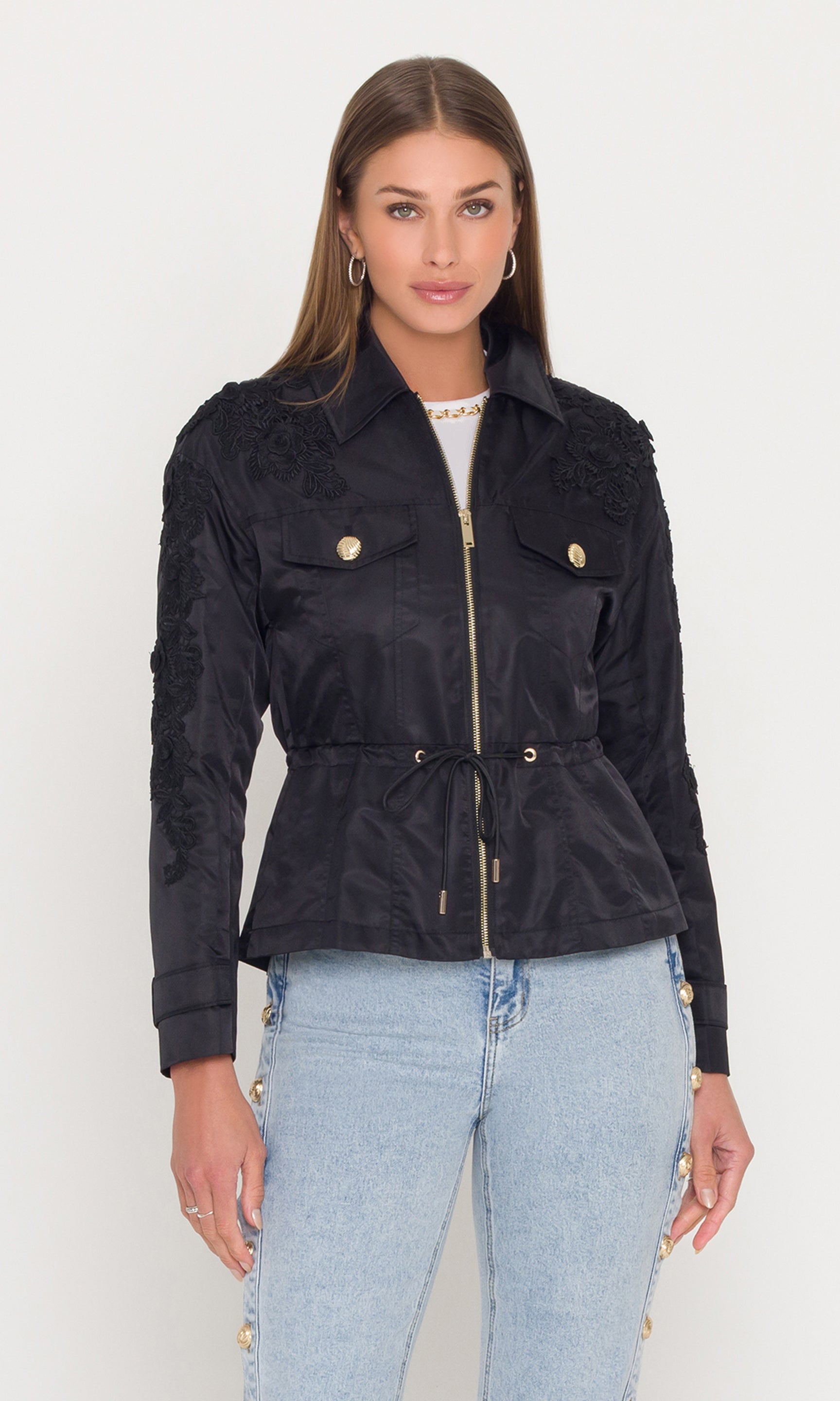 Woman wearing a black jacket with gold buttons on a white background