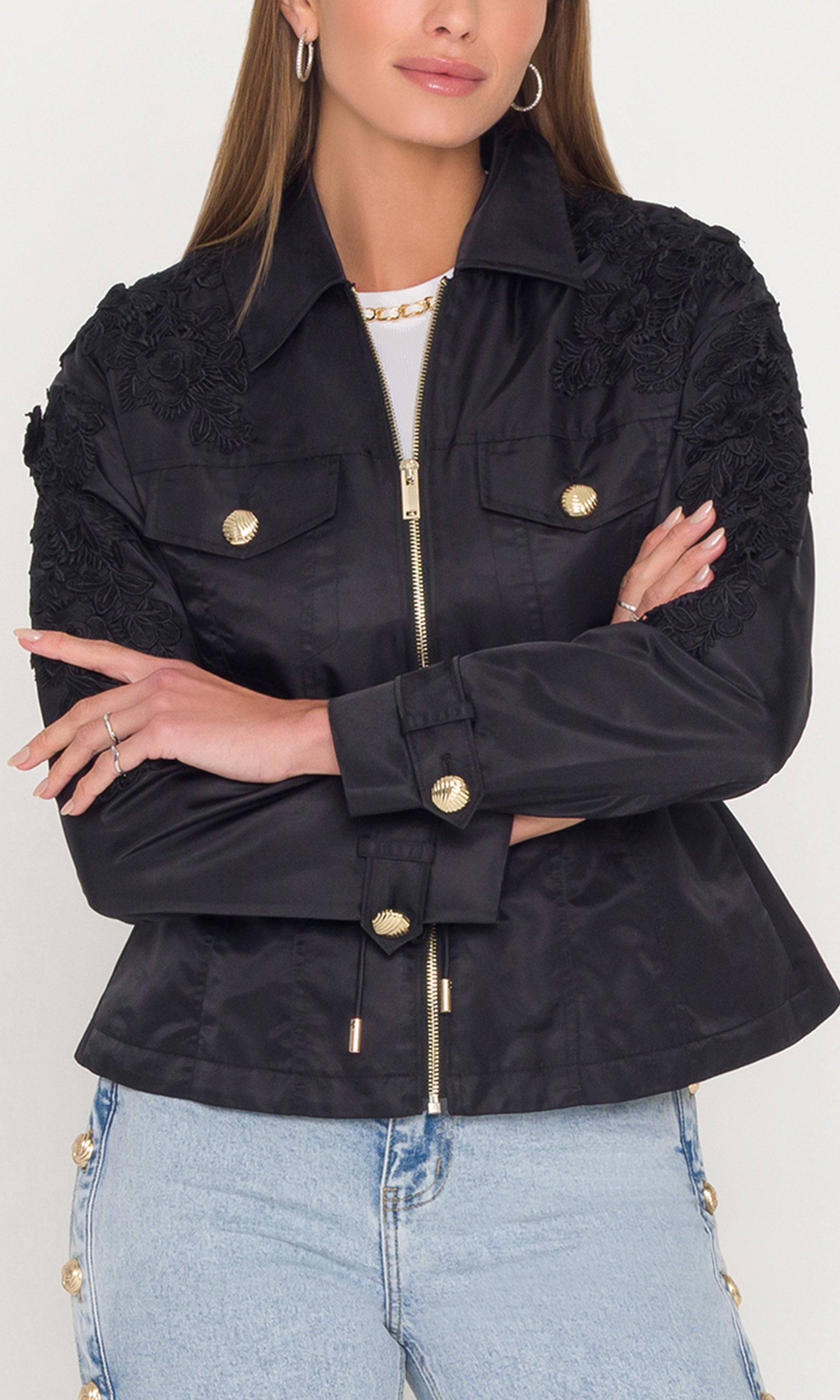 Black jacket with floral embroidery and gold buttons worn by a person on a white background
