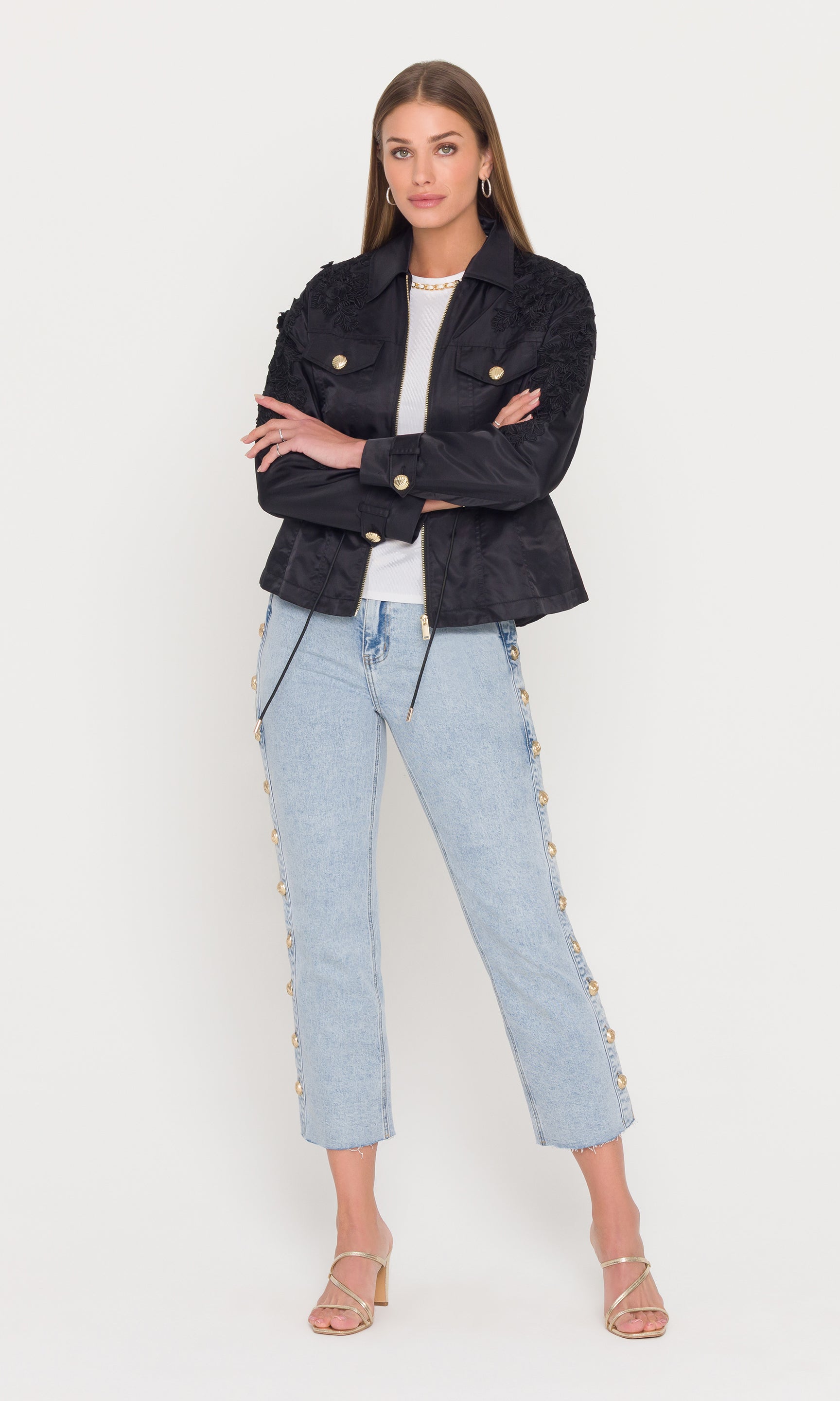 Full body image of woman wearing a black parka jacket and light blue jeans on a white background