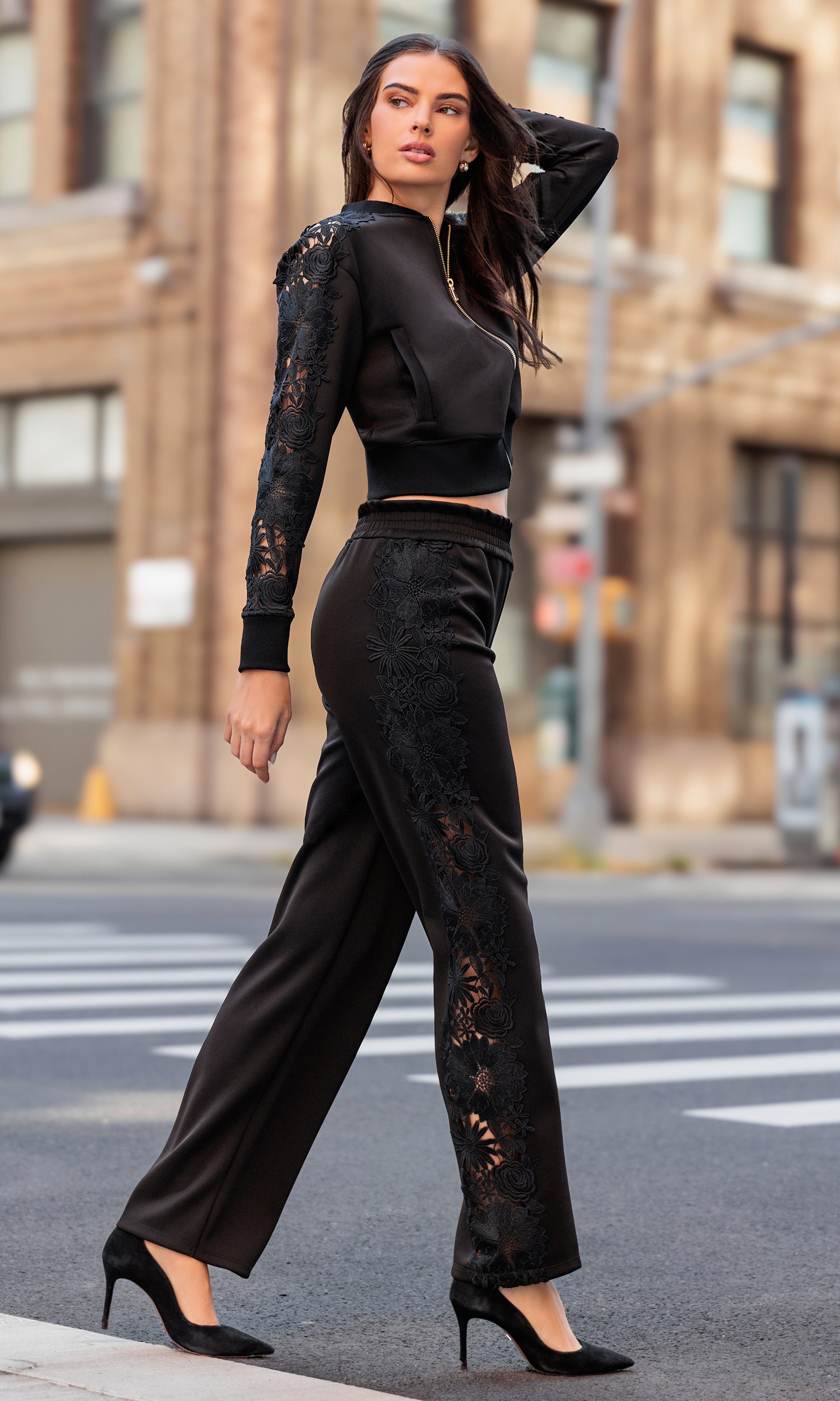 Woman in a black lace outfit walking on a city street