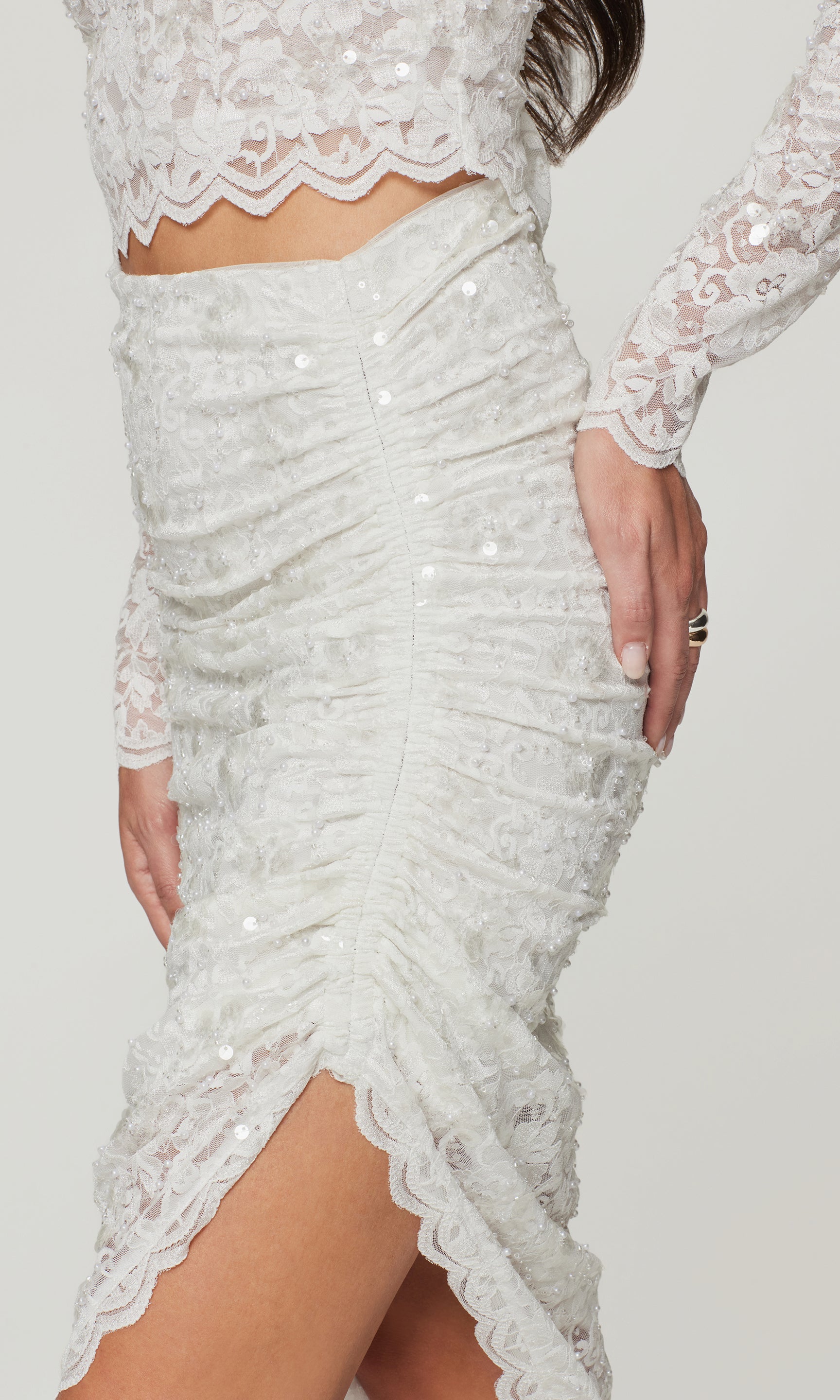 White lace skirt with sequin detailing on a plain background