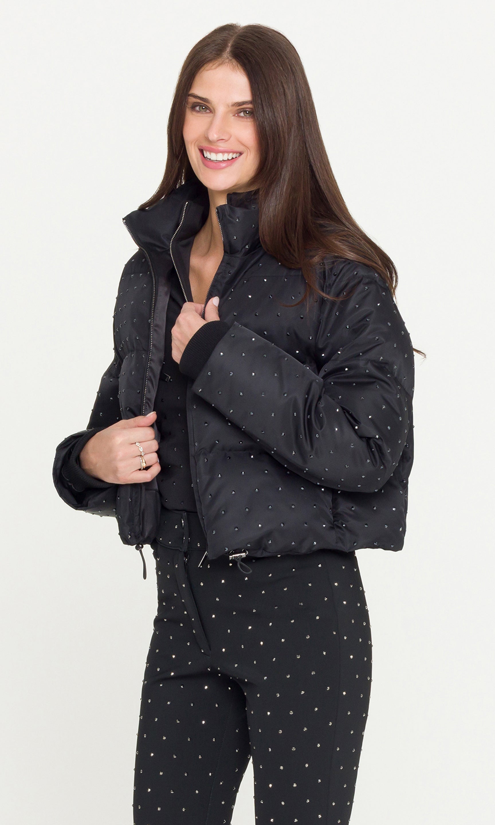 Side view of model wearing a black crystal embellished puffer over a matching black jacket and pants