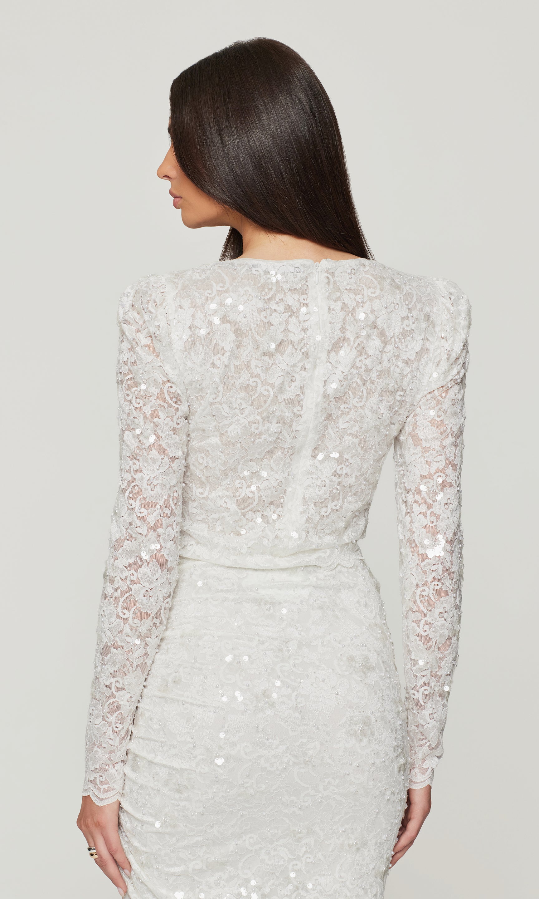 White sequin dress worn by a model on a plain background