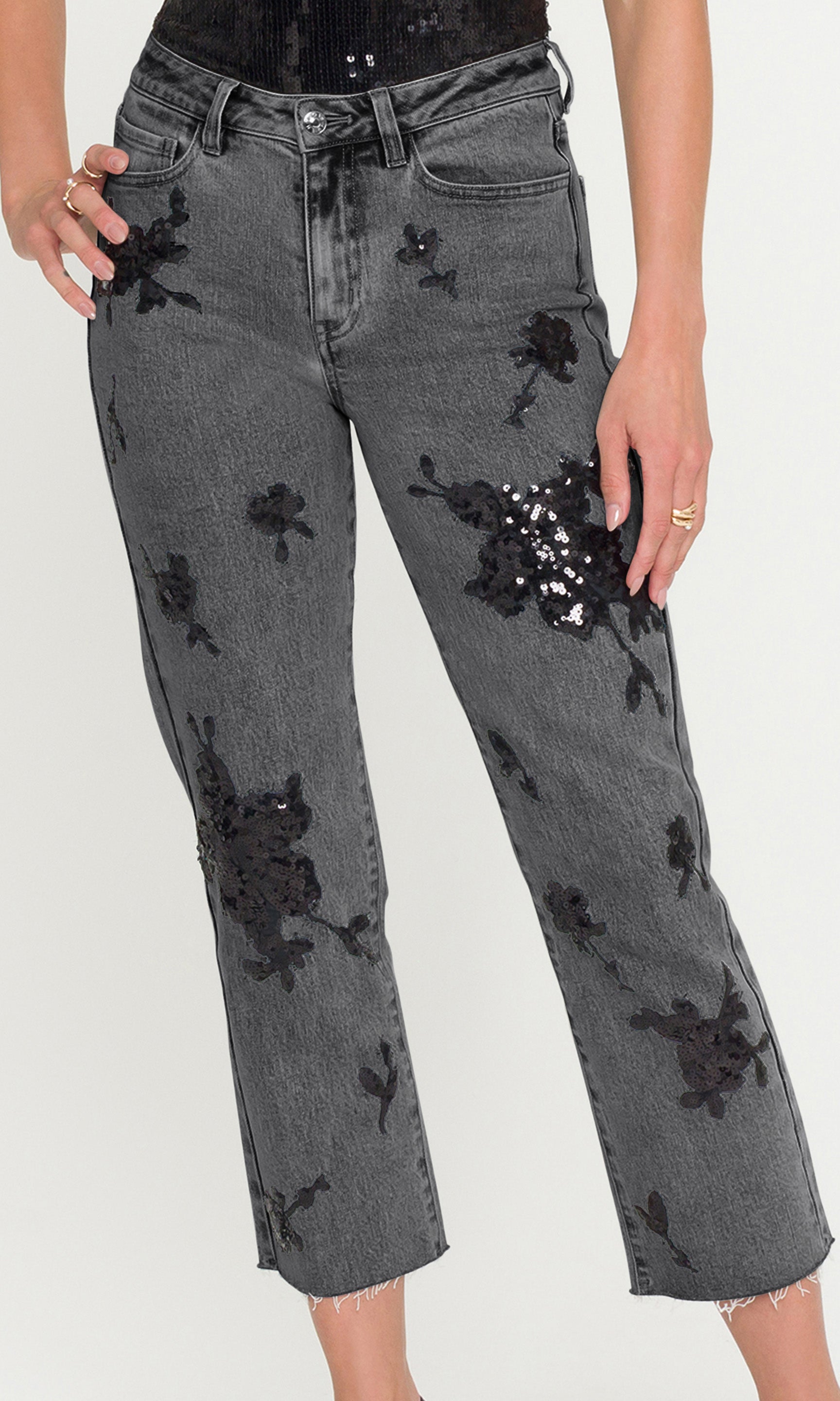 Gray jeans with black floral embroidery on a white background