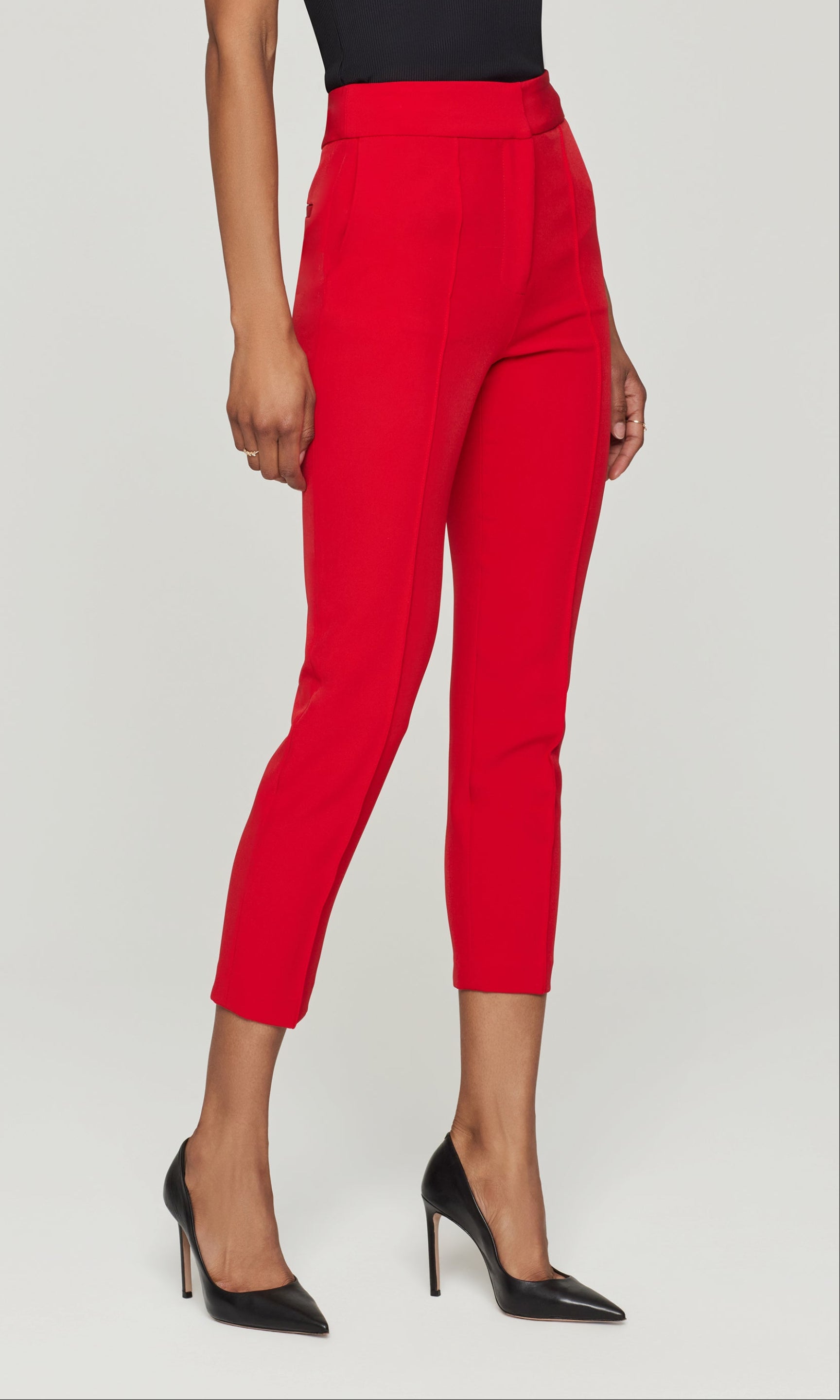 Side view of red pants worn by a person on a white background