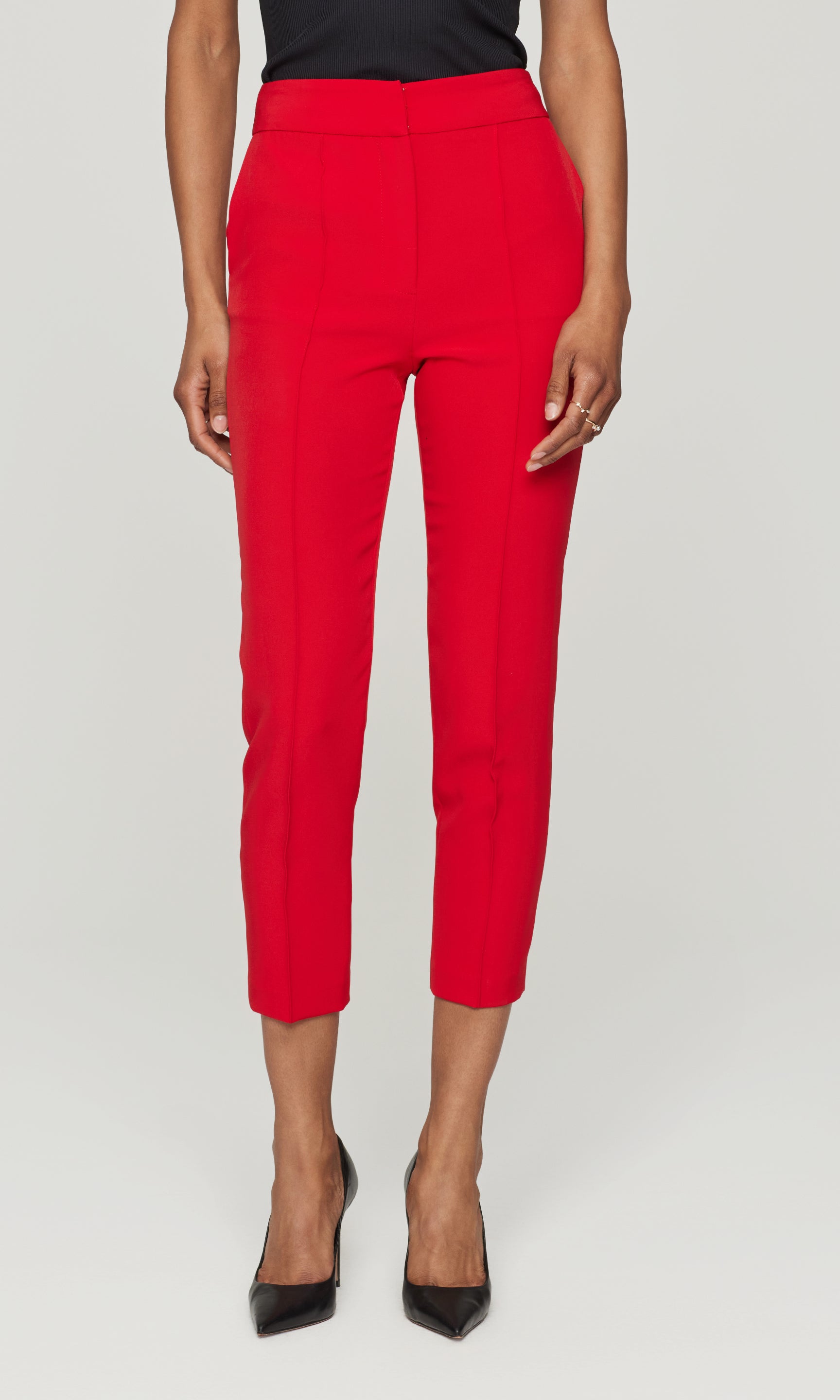 Red pants worn by a person on a white background