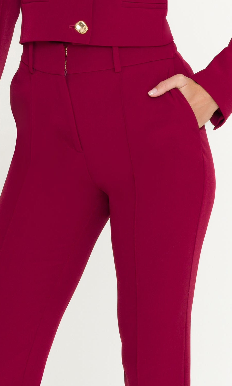 Person wearing a red outfit with high-waisted pants on a white background
