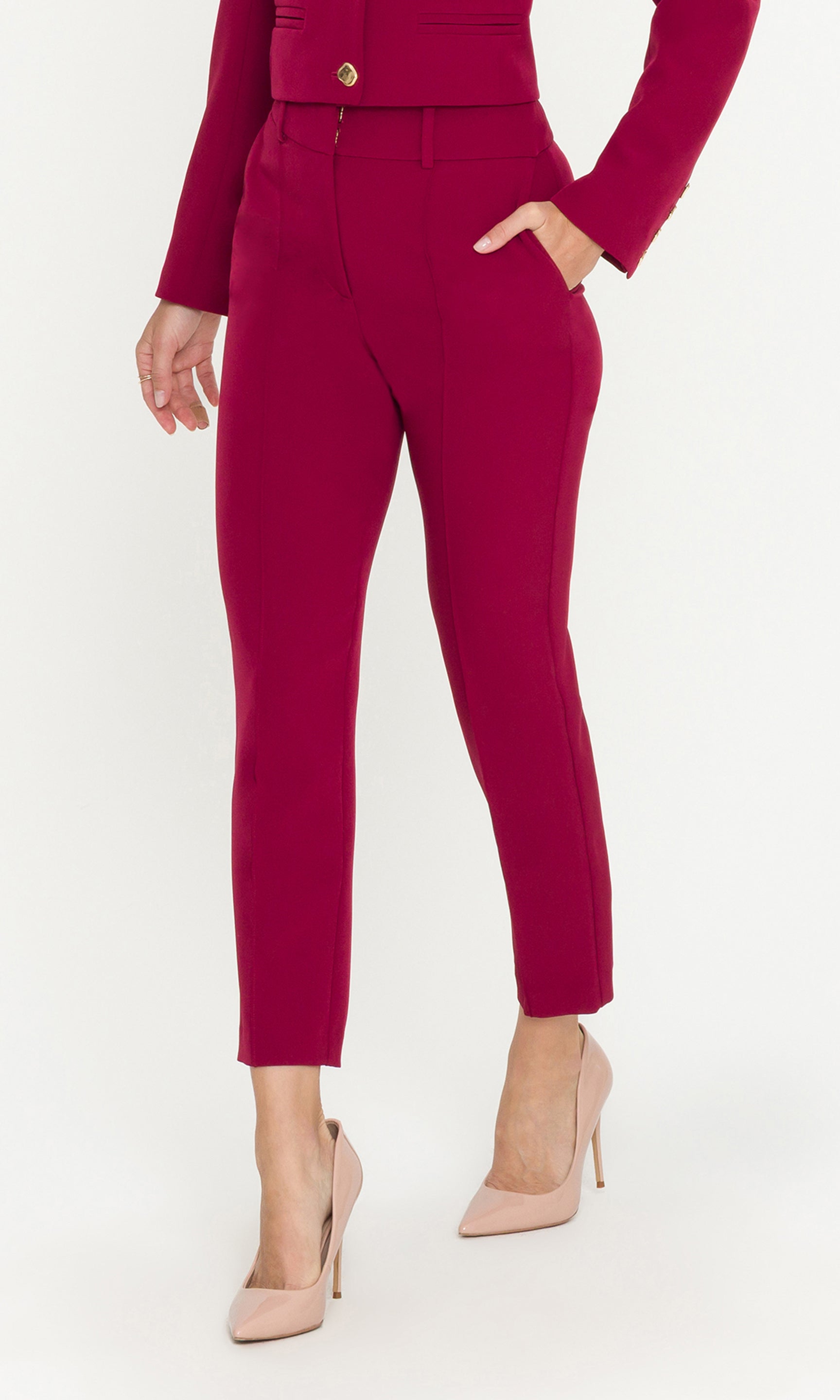 Person wearing a red outfit with high-waisted pants on a white background