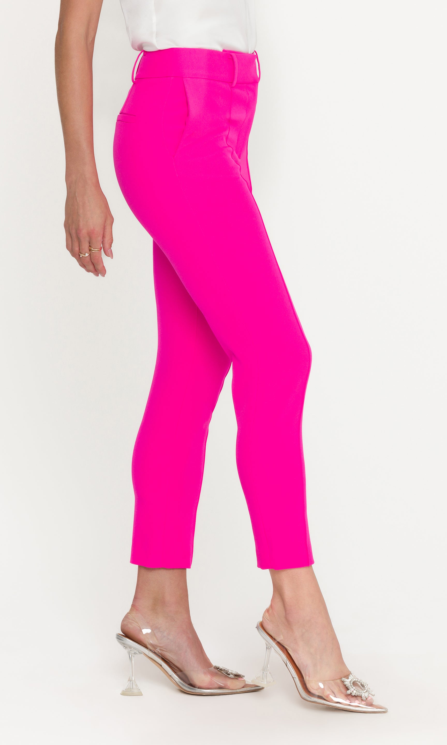 Bright pink pants worn by a person on a white background