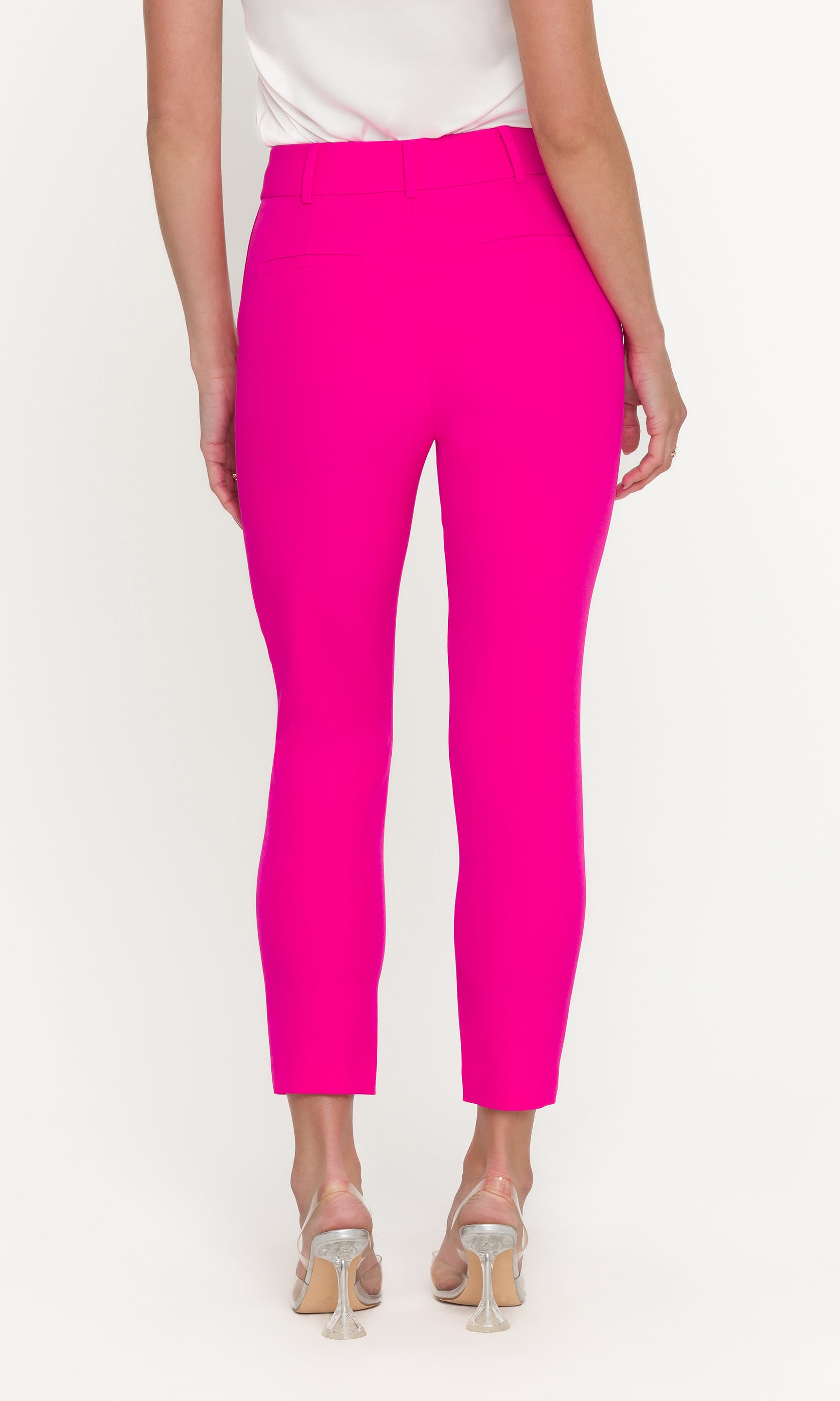 Person wearing bright pink pants on a white background