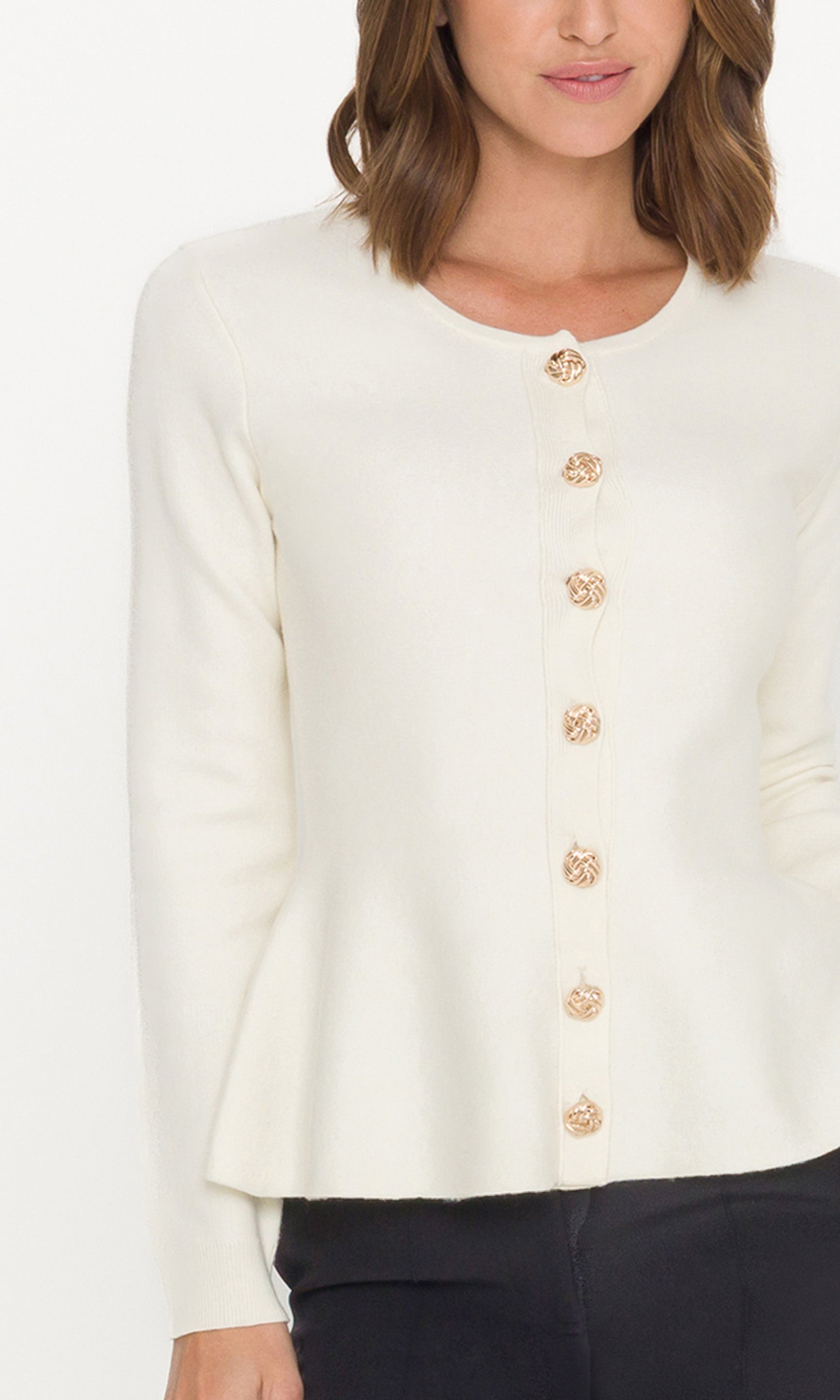 Detail image of white cardigan with gold buttons worn by a person on a white background