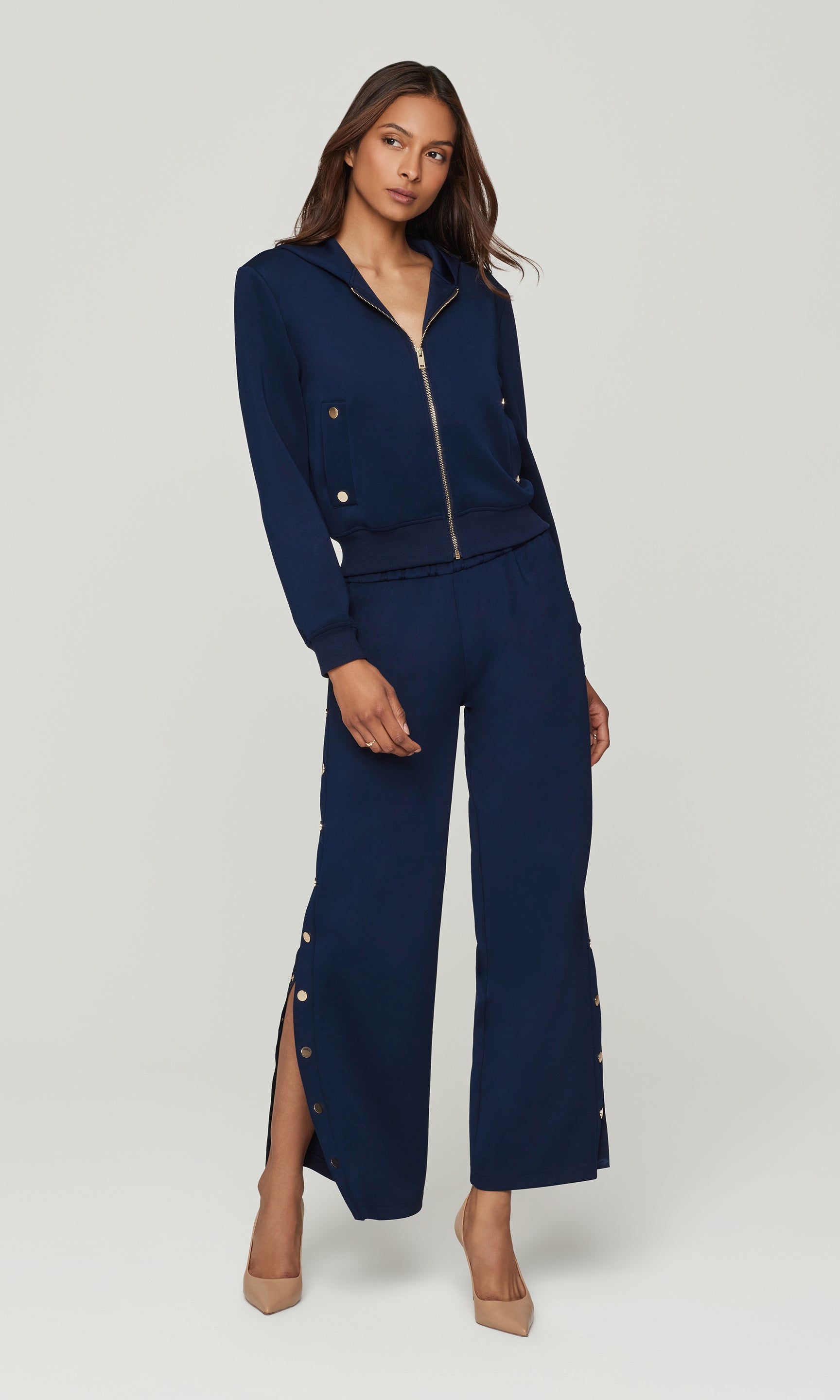 Woman wearing a navy blue outfit with a white background