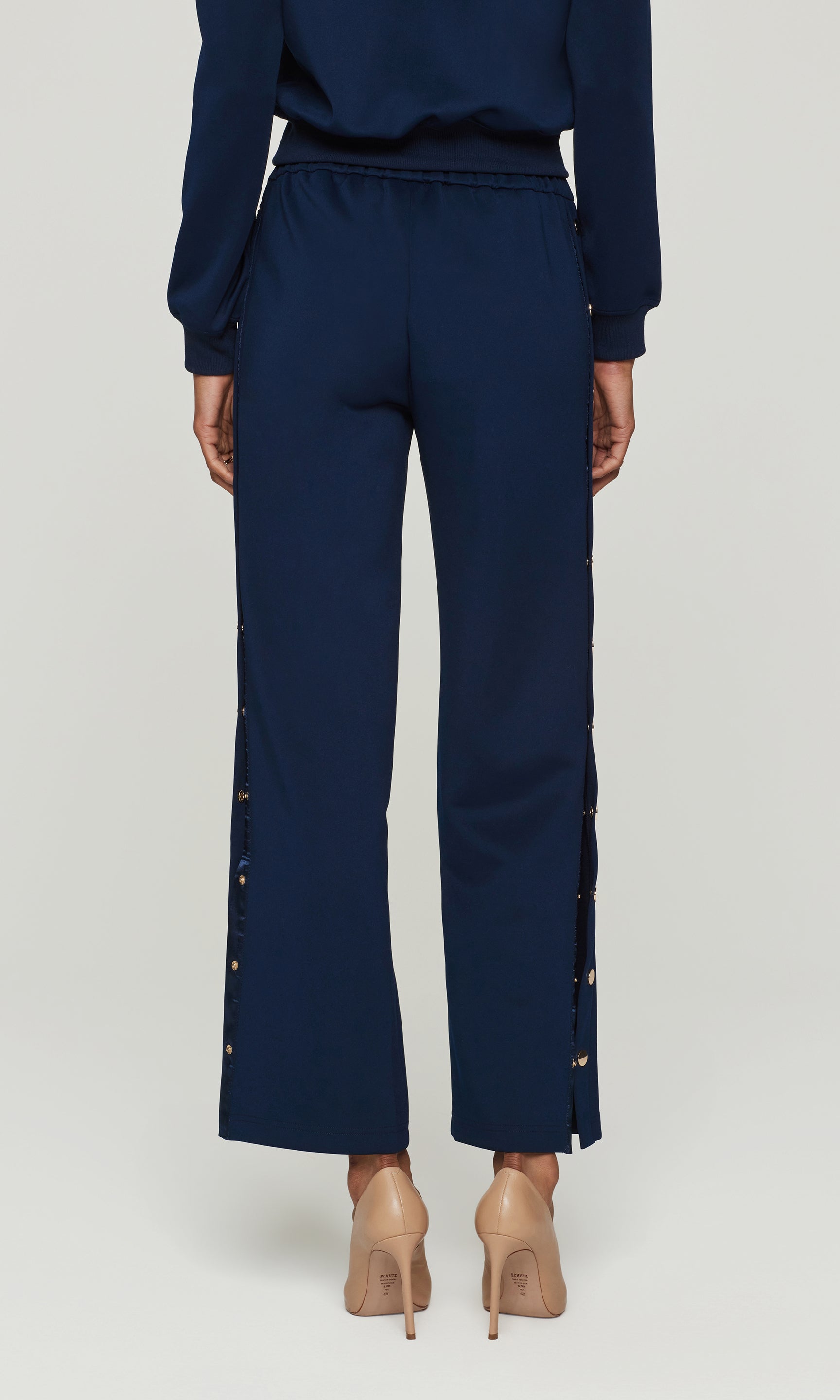 Navy blue pants with decorative side panels on a white background