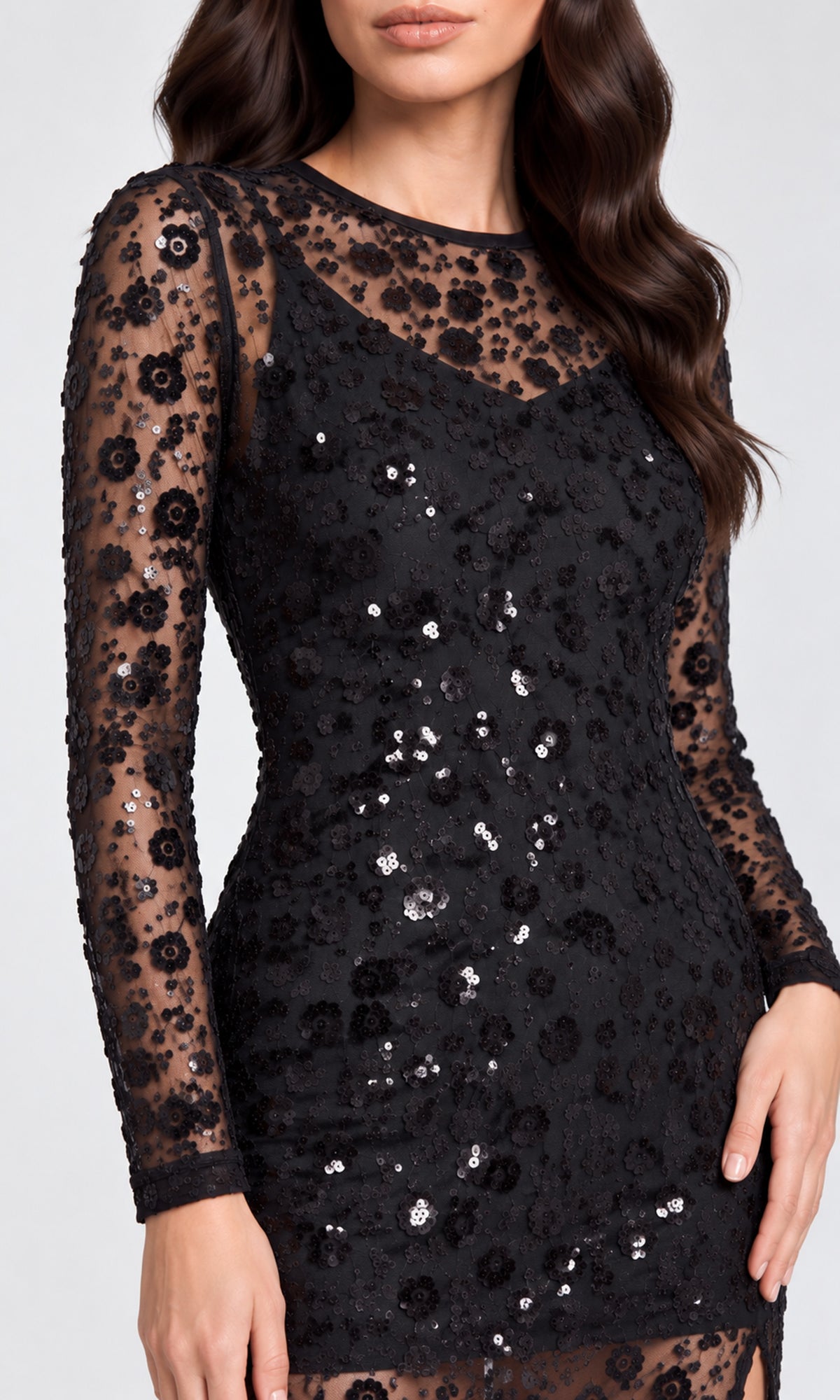 Close-up of a black long-sleeve bodycon dress with sheer floral lace sleeves and sequined floral applique.