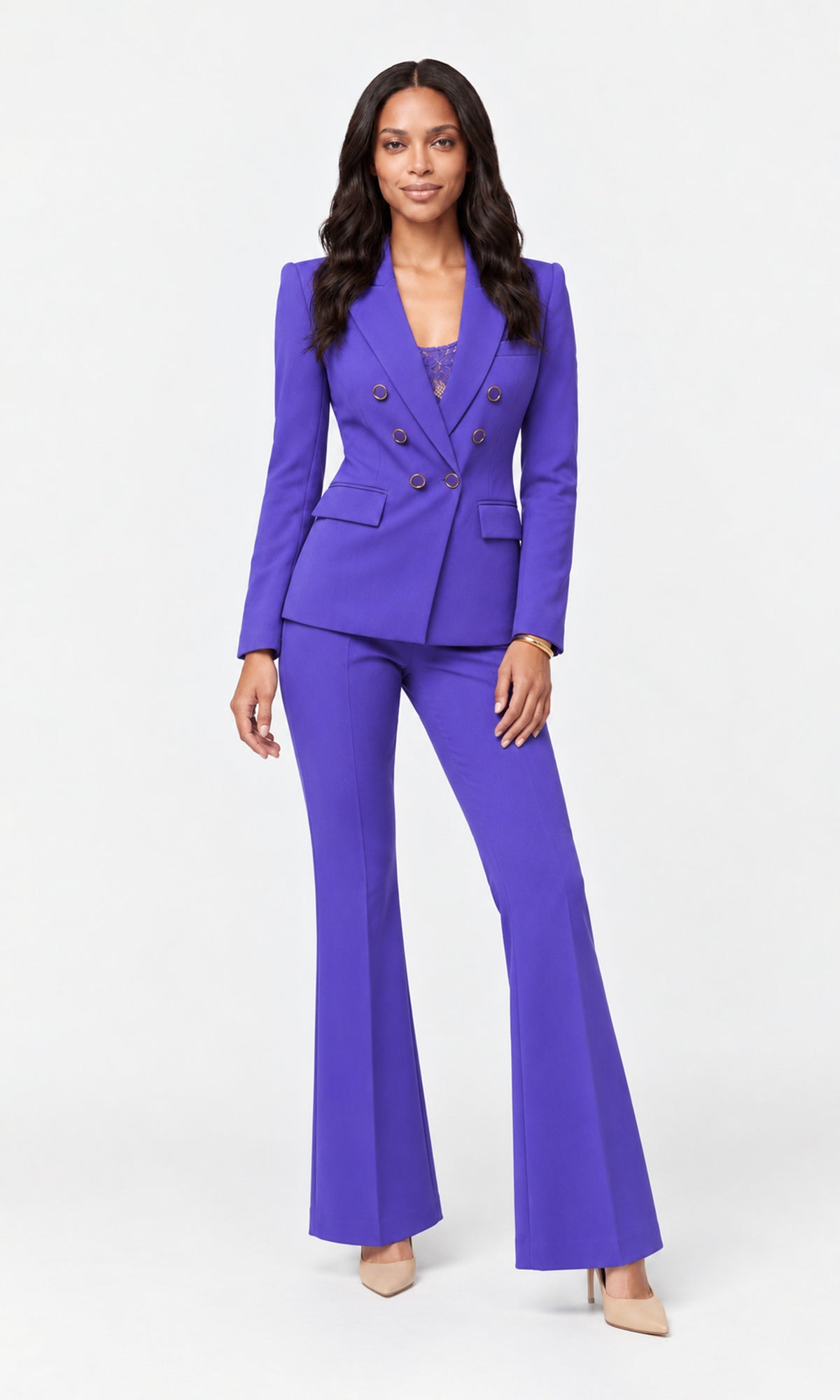 A woman modeling a vibrant purple two-piece pantsuit with a double-breasted blazer and matching flared trousers.