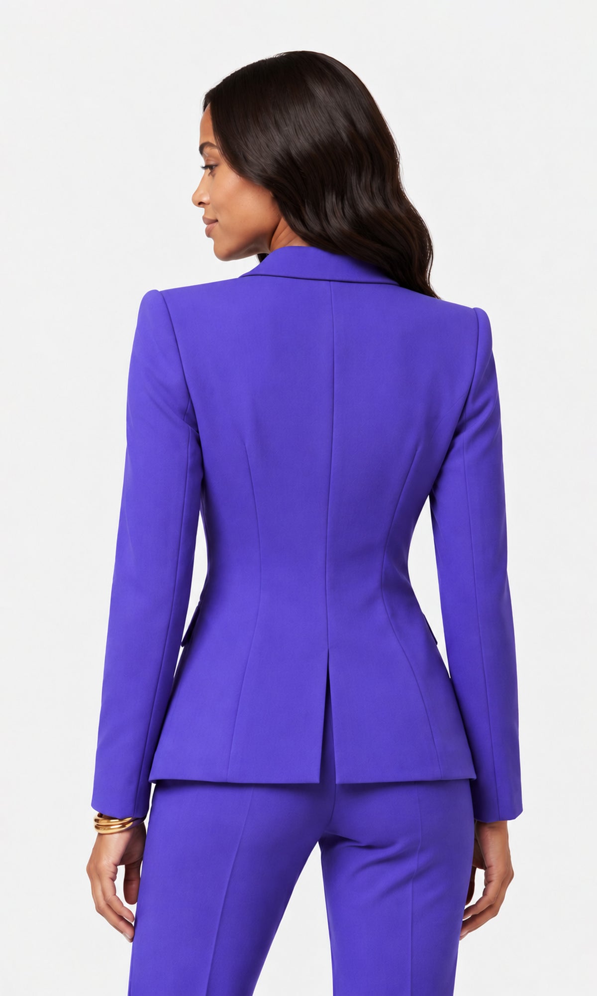 Back view of woman modeling a vibrant purple double-breasted blazer and matching trousers.