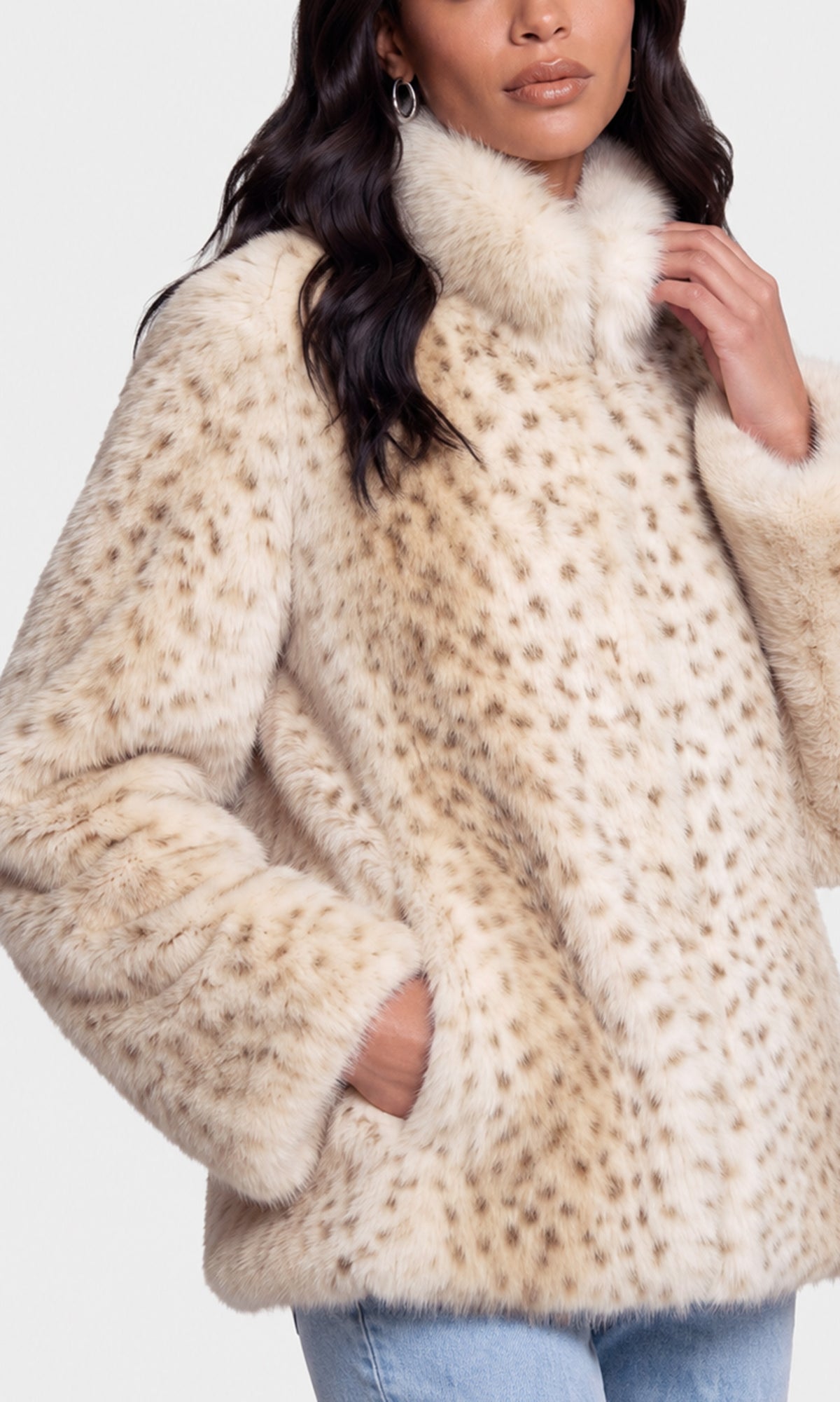 A close-up of a model wearing a beige faux fur jacket with a brown spotted leopard print pattern and a high fluffy collar.